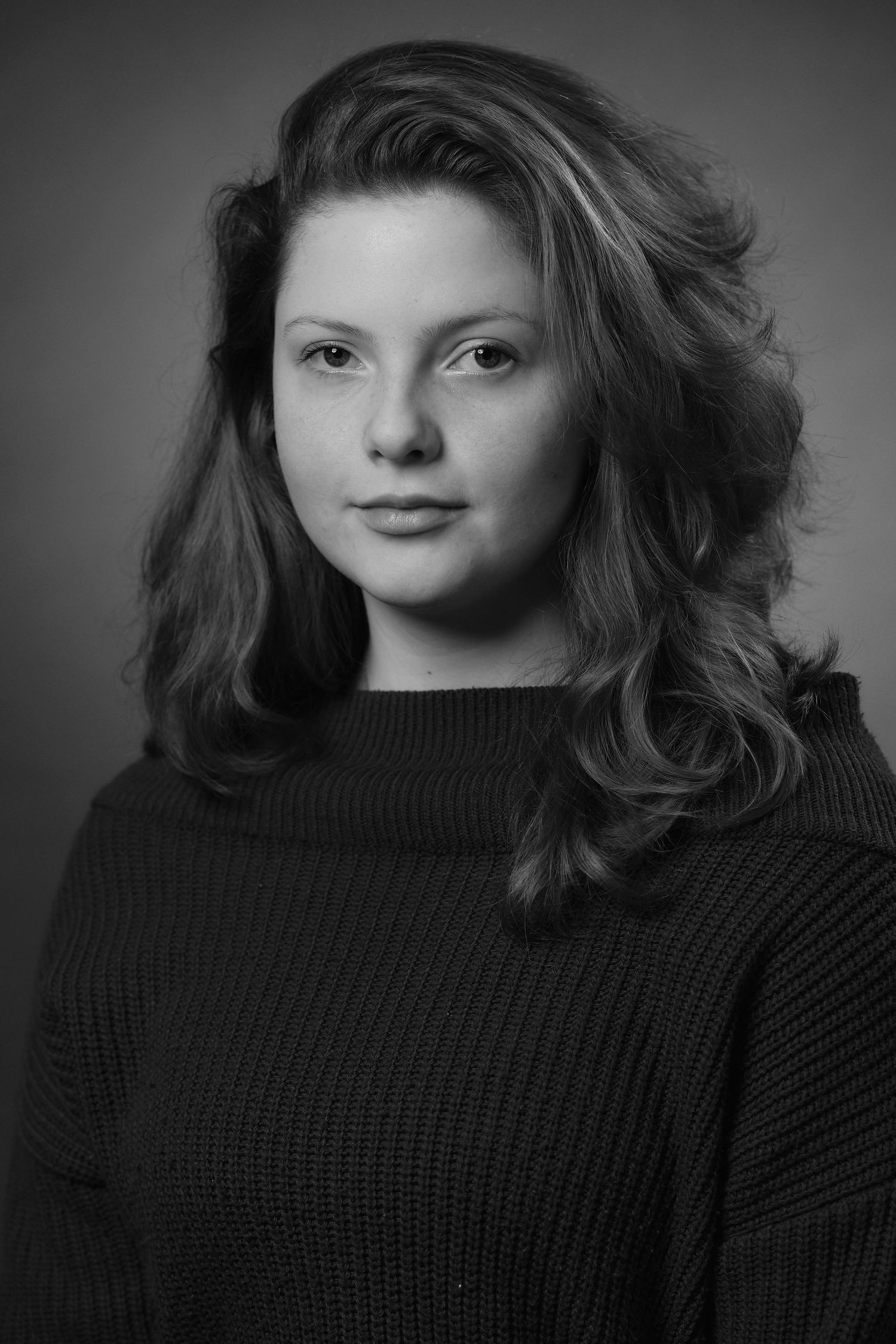 Black and white portrait series showing different angles in moody lighting.