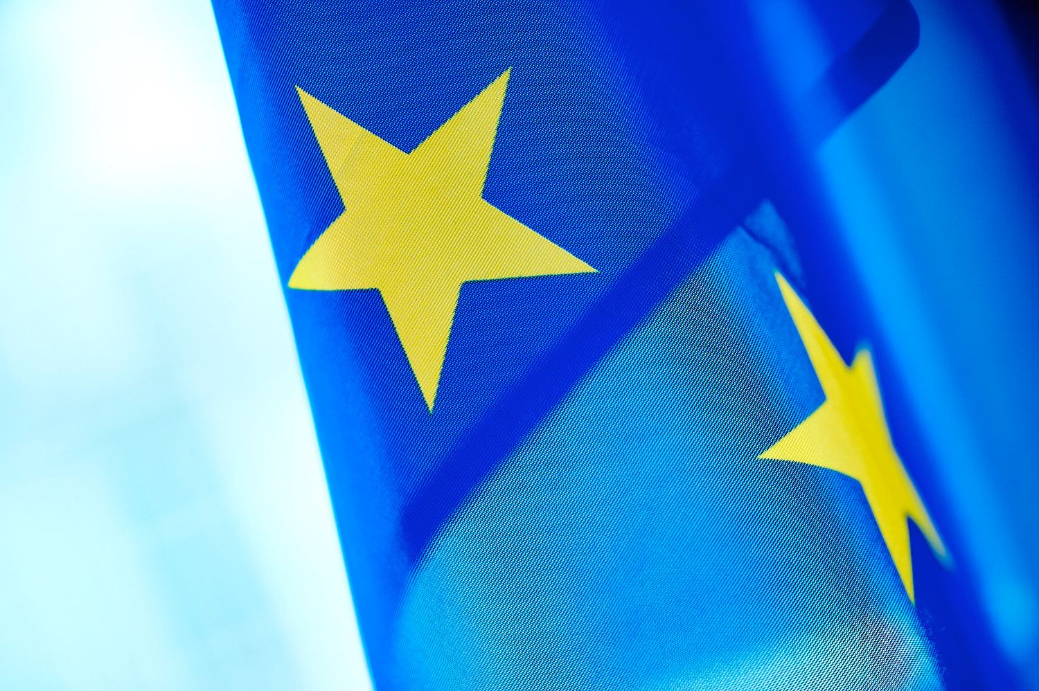 Close-up of European Union flag with yellow stars on blue background.