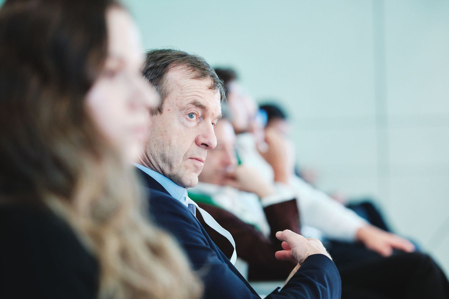 Row of attendees seated and focused during business conference session.