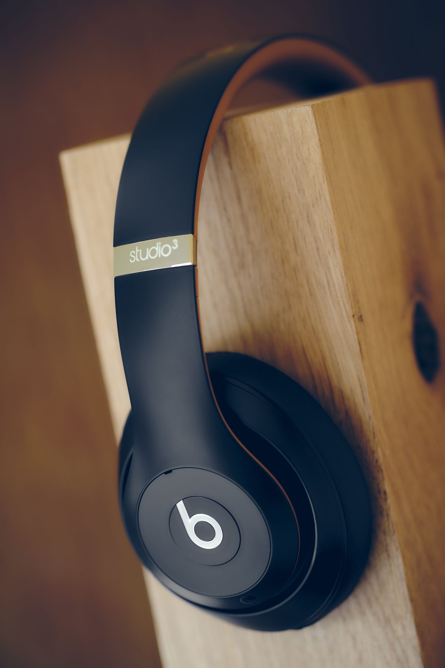 Black Beats Studio wireless headphones displayed against a wooden background.