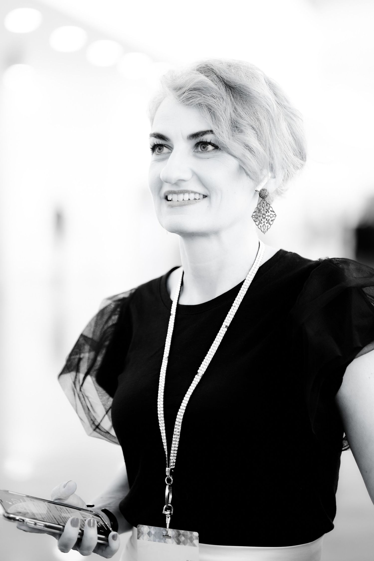 Black and white portraits of person in black outfit with statement earrings.