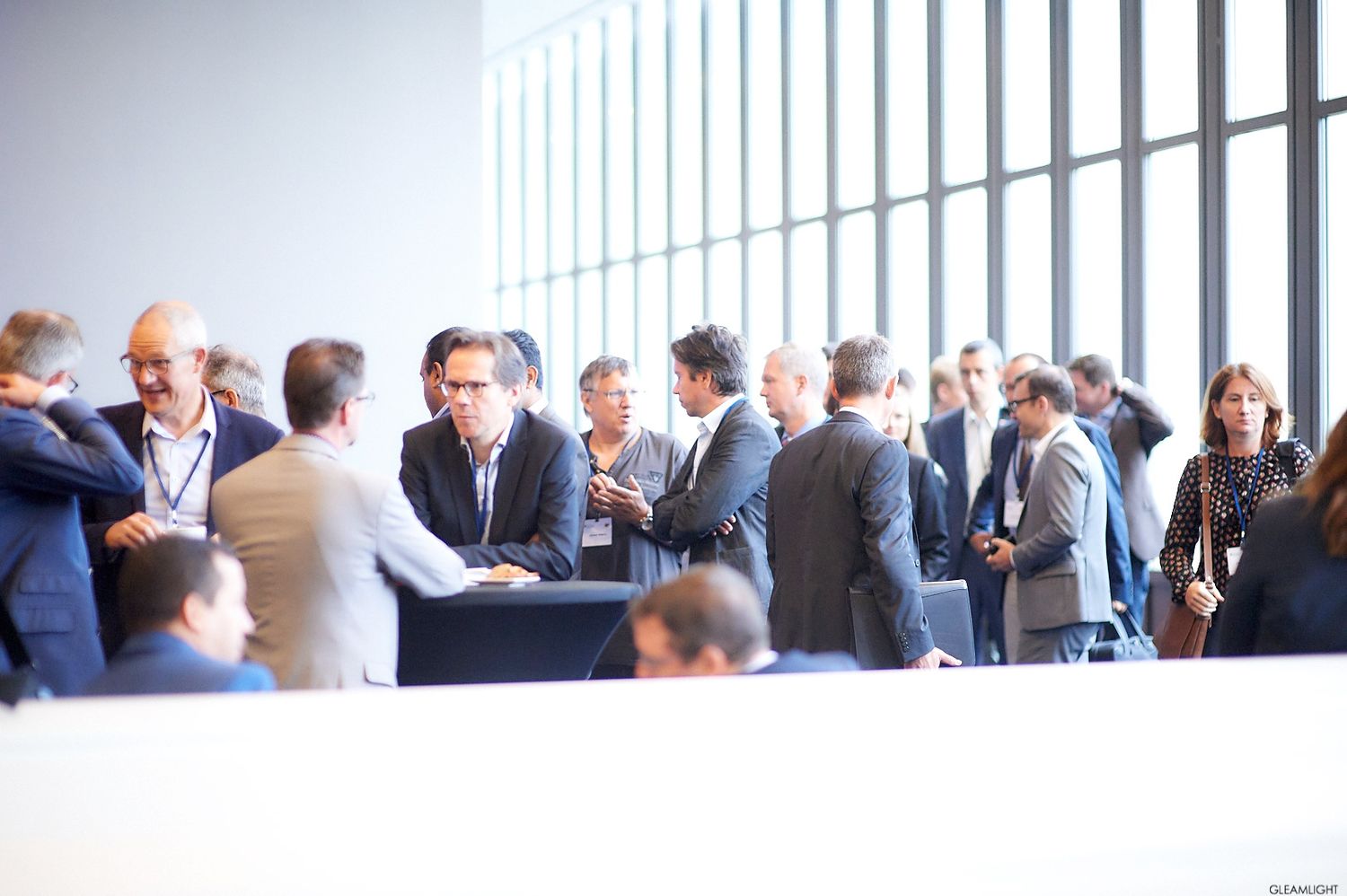 Group of business professionals networking in a bright modern office space.