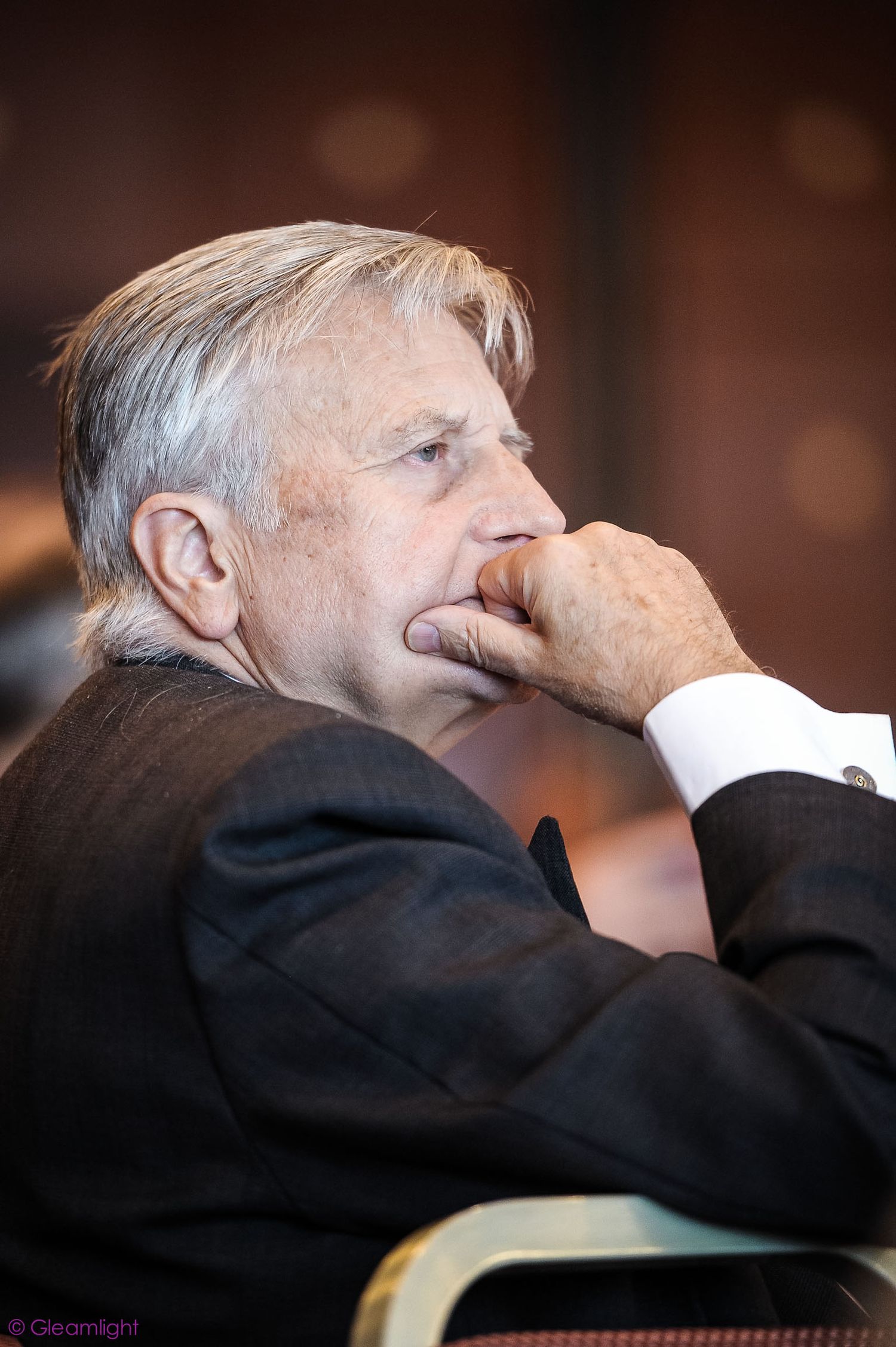 Side profile view of attendee listening intently during conference session.