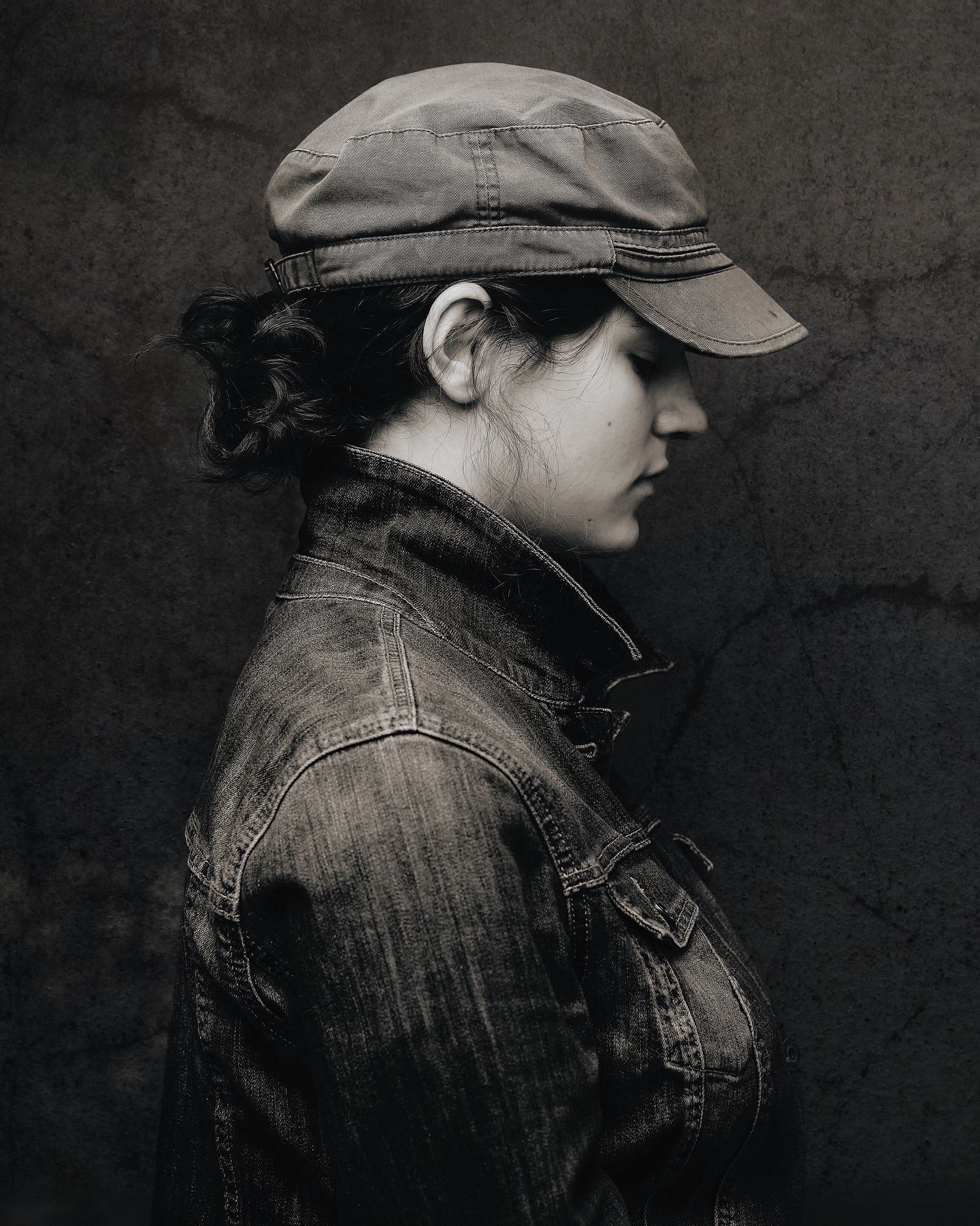 Moody portraits in denim jacket and cap showing different side angles.