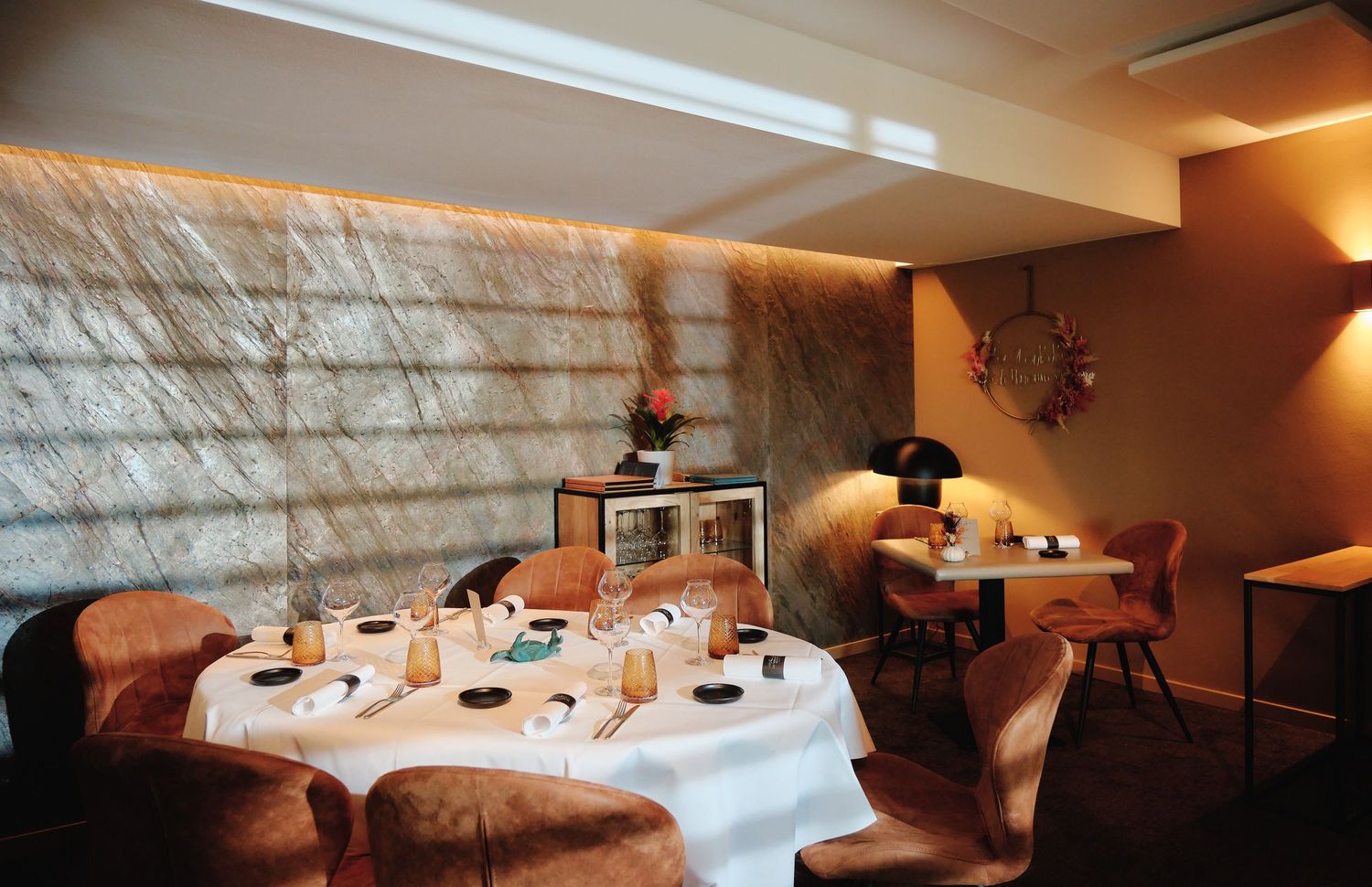 Elegant restaurant interior with curved booth seating and modern lighting creating an intimate dining atmosphere.