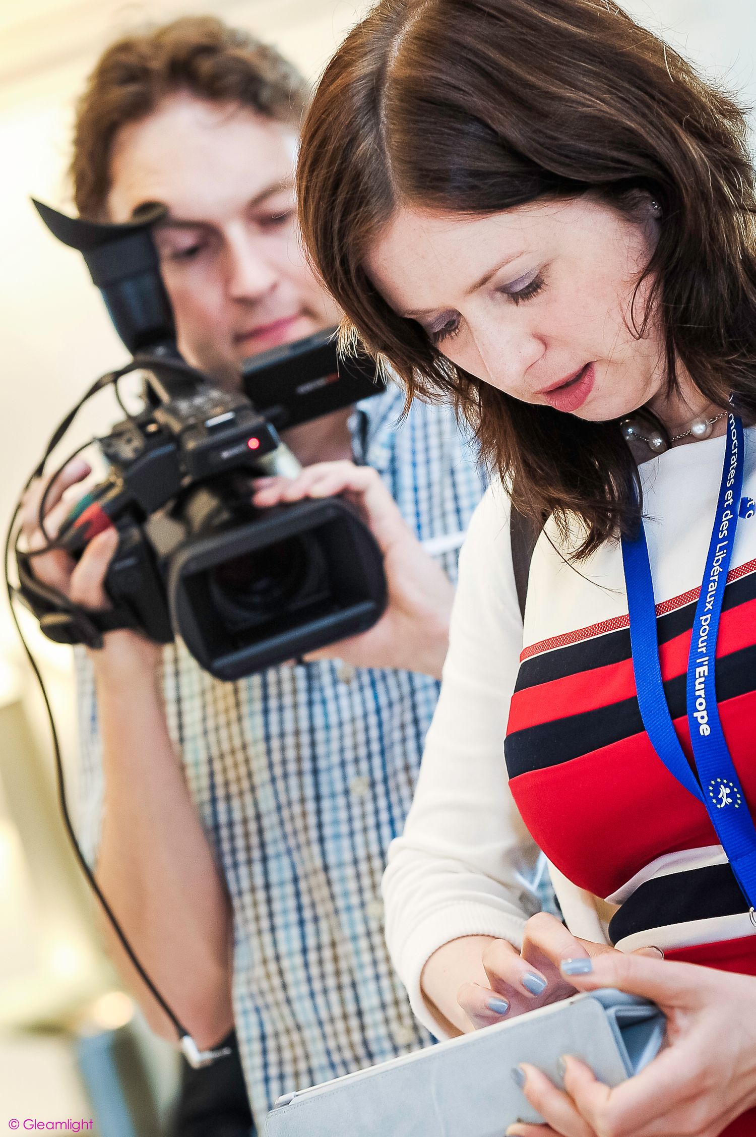 Journalists and photographers documenting event with professional camera equipment.