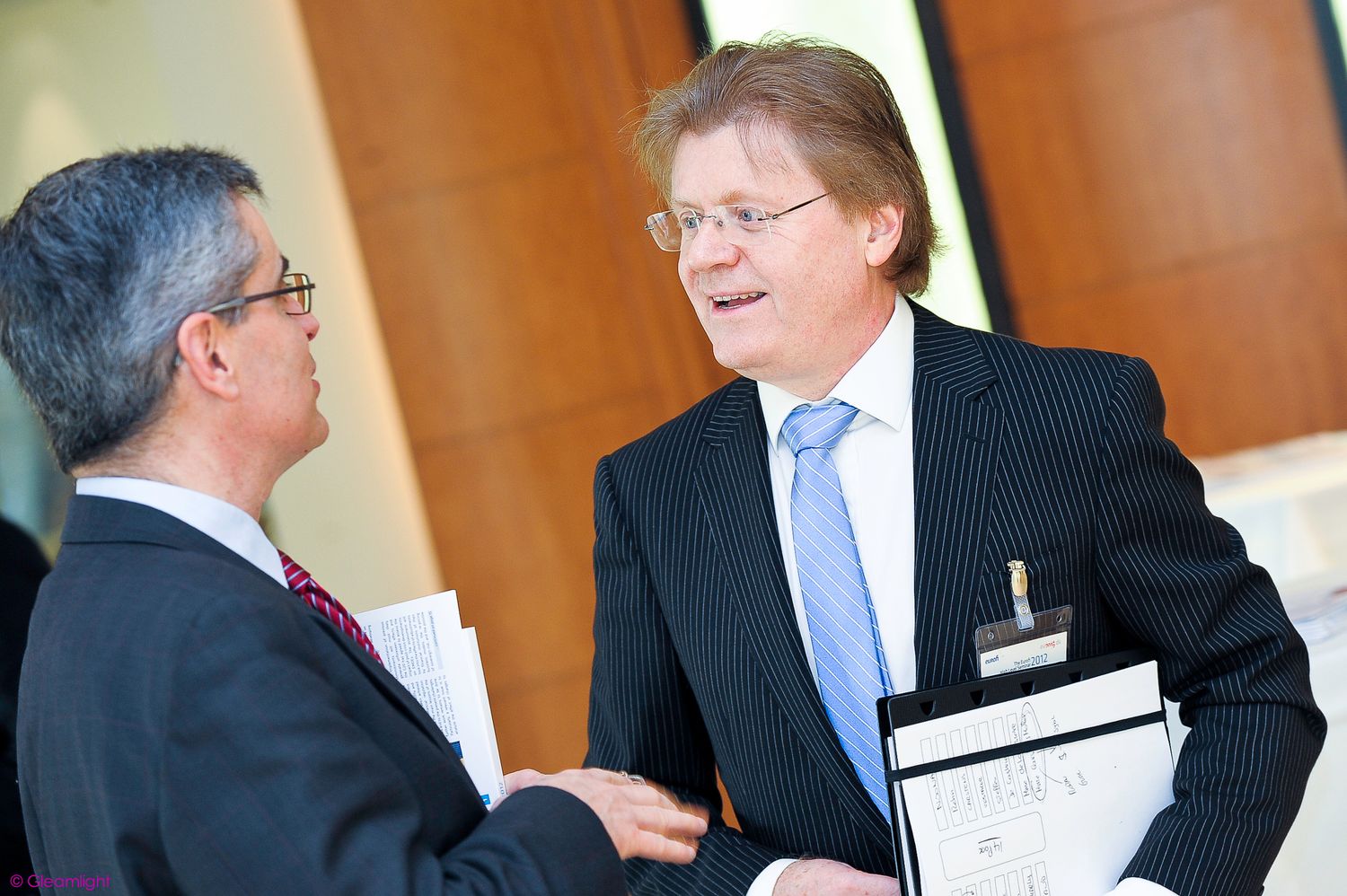 Business professionals interacting during a networking event in a conference setting.