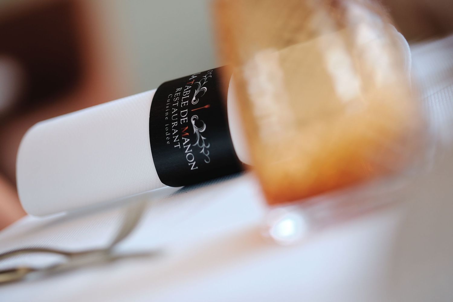 Close-up detail of elegant table settings with wine glasses and ambient lighting in an upscale restaurant.
