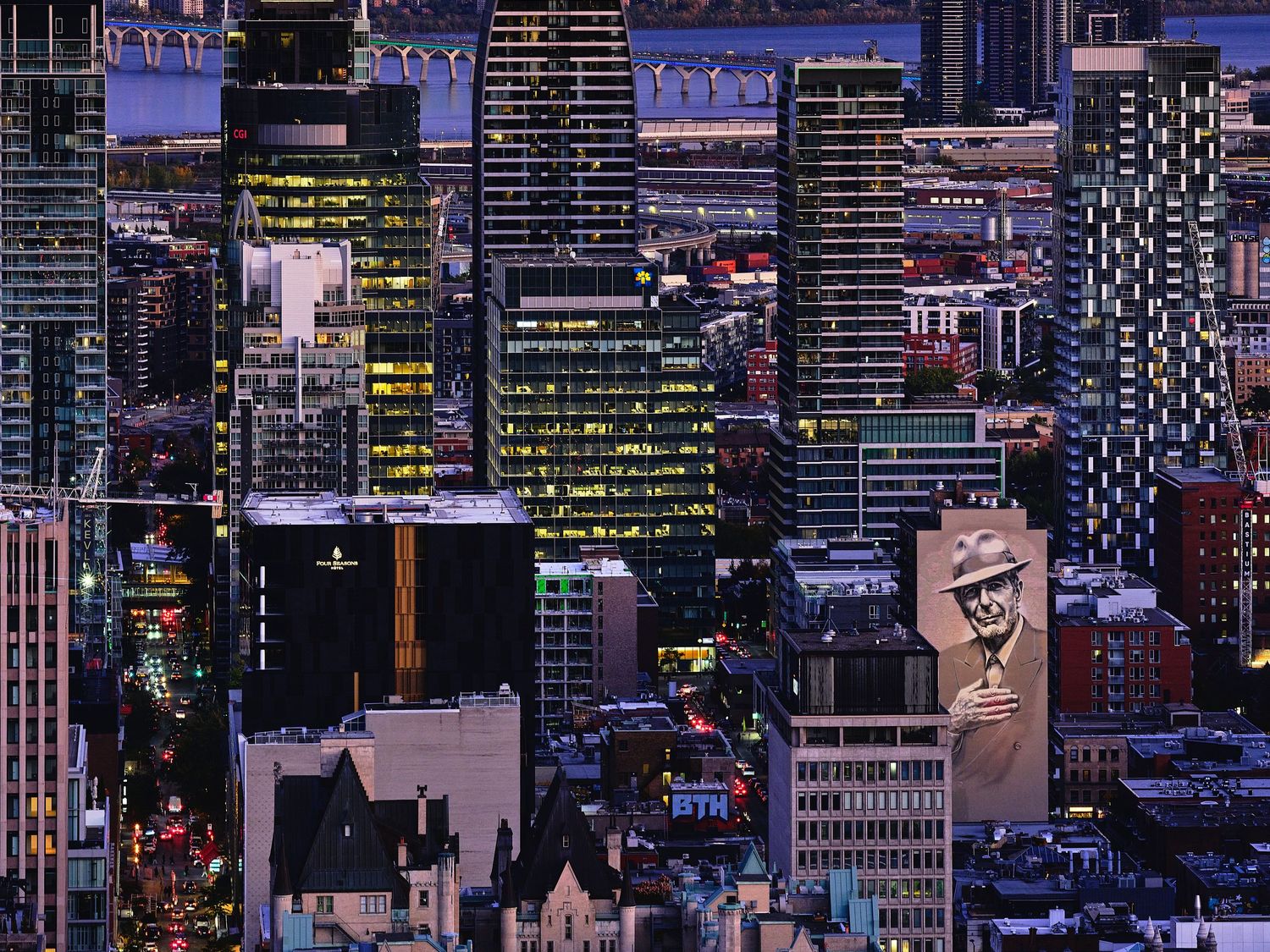 Night cityscape showing illuminated skyscrapers and office buildings in dense urban setting.