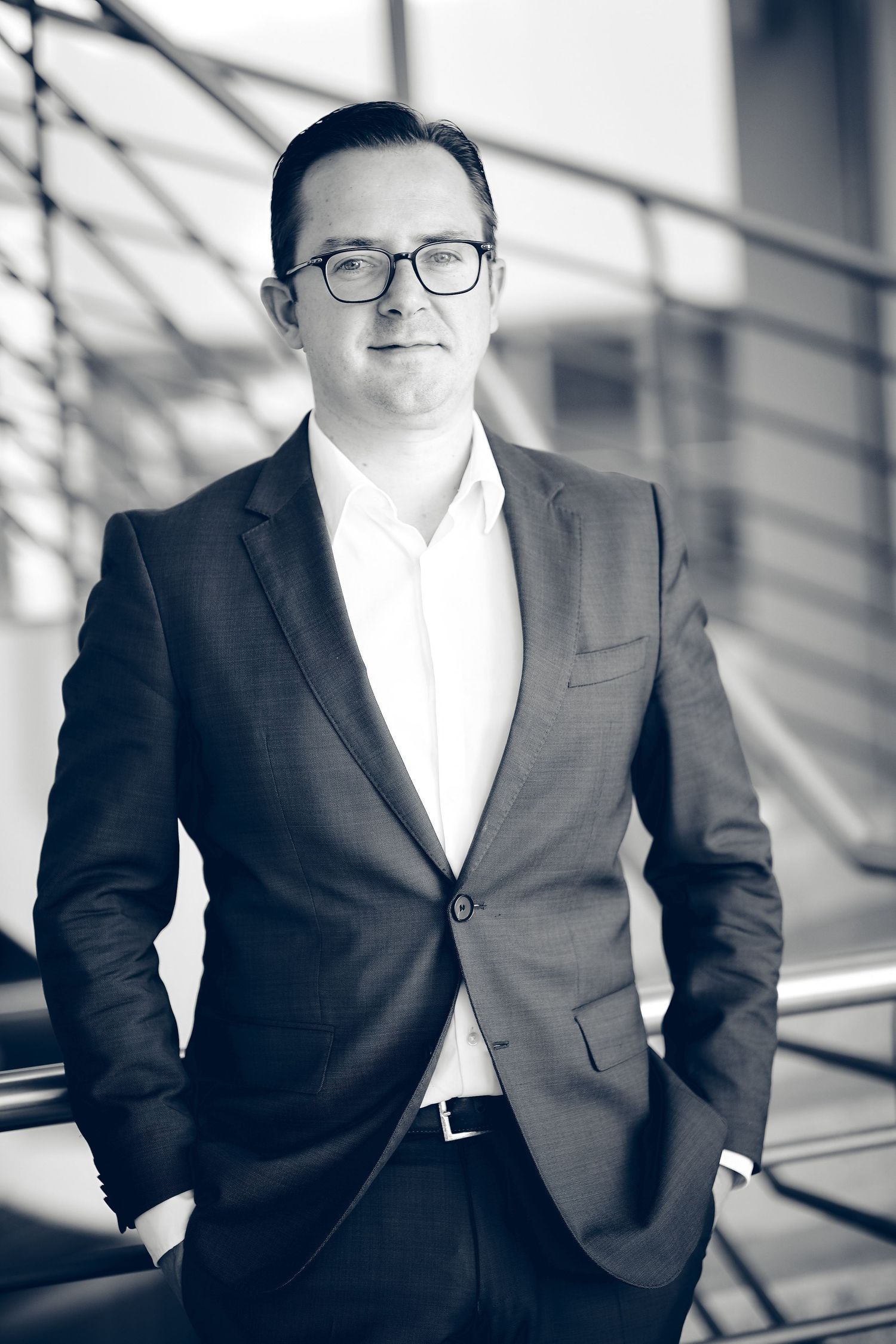Professional portraits of executive in modern office setting with natural light.