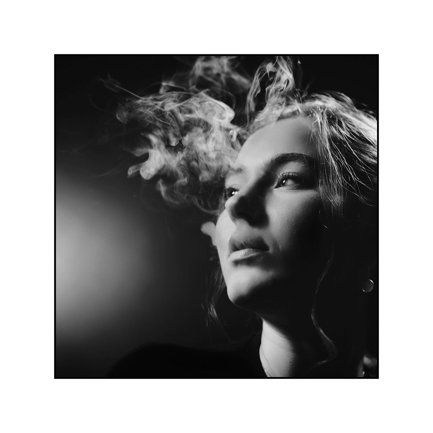 Dramatic close-up portrait with smoke effects in dark lighting.