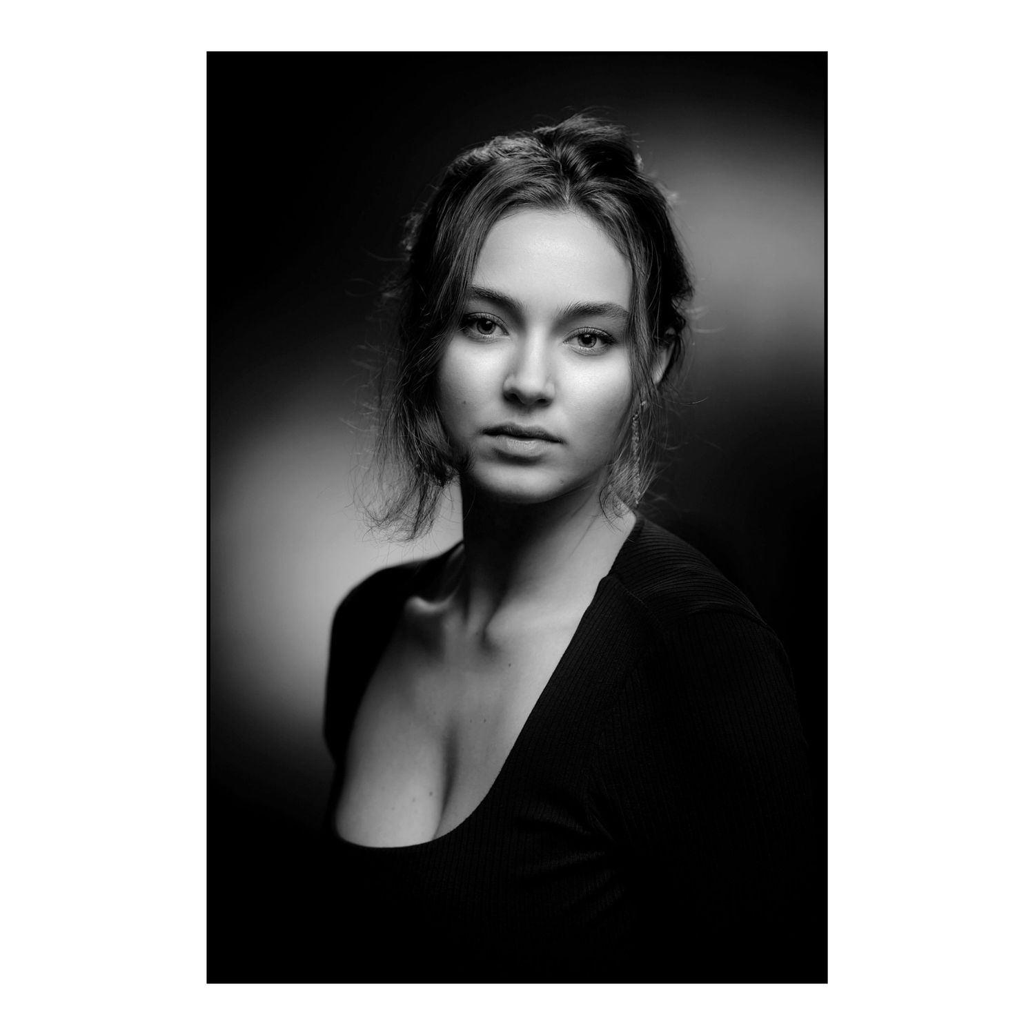 Dramatic black and white portrait with moody lighting and dark shadows creating an artistic composition.