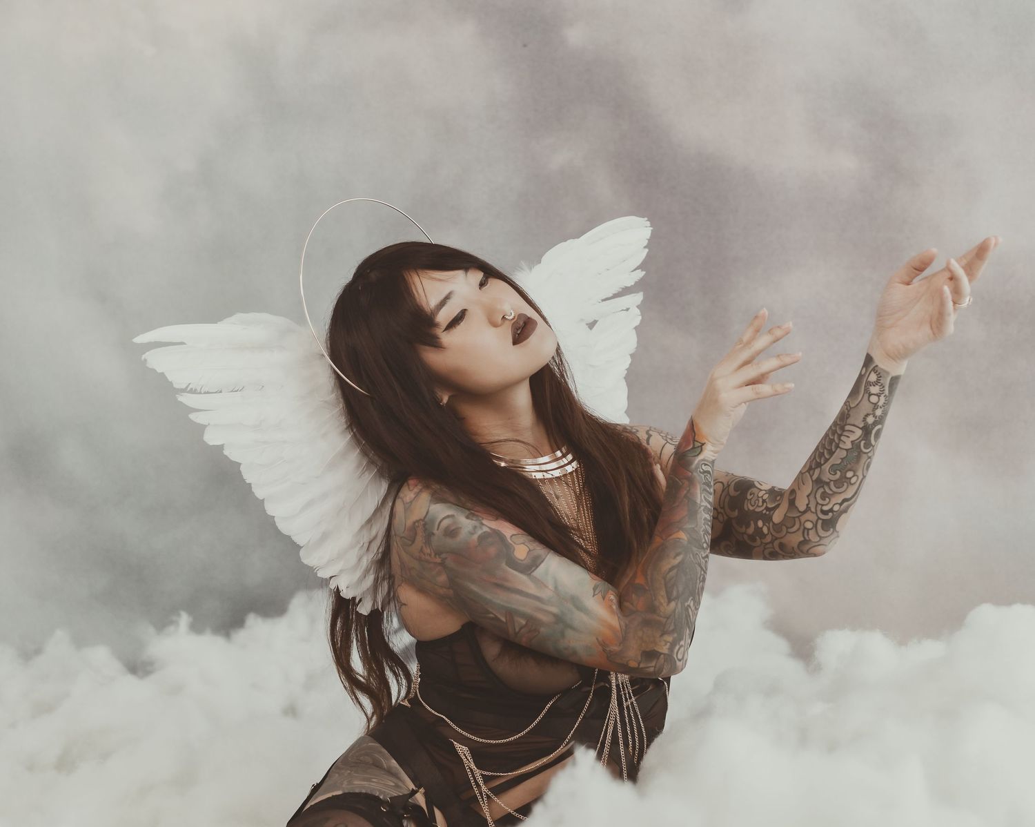 Ethereal angel themed photo with dramatic poses against stormy sky background.
