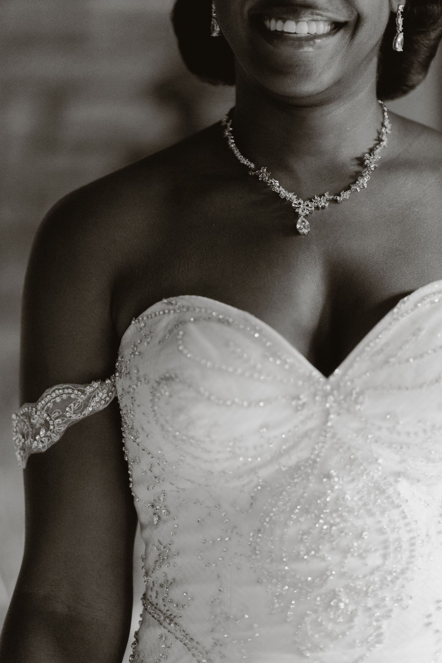 Close-up detail of sparkling wedding dress bodice and crystal necklace.