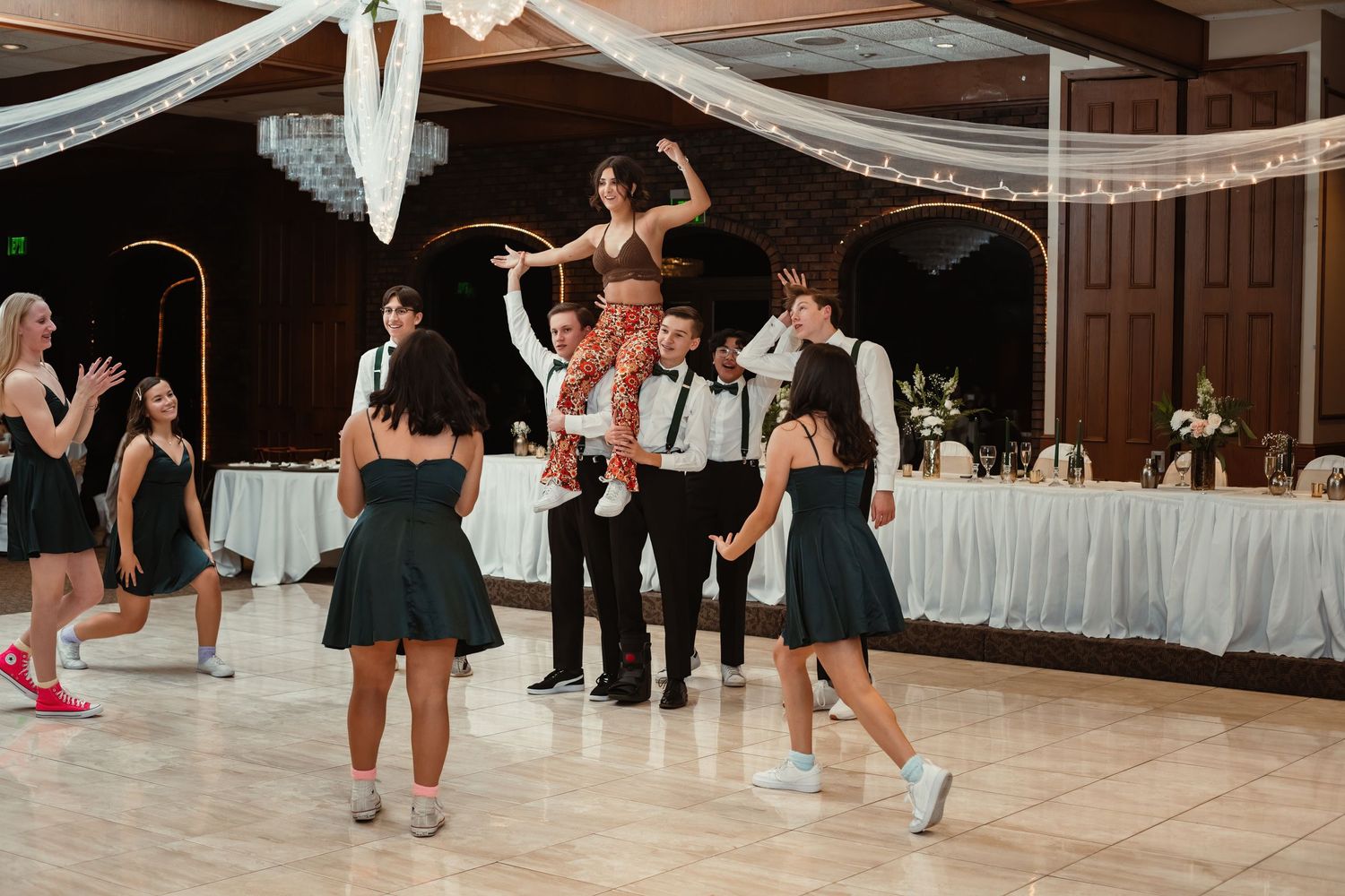 Wedding guests dance and celebrate on the dance floor during a reception party.