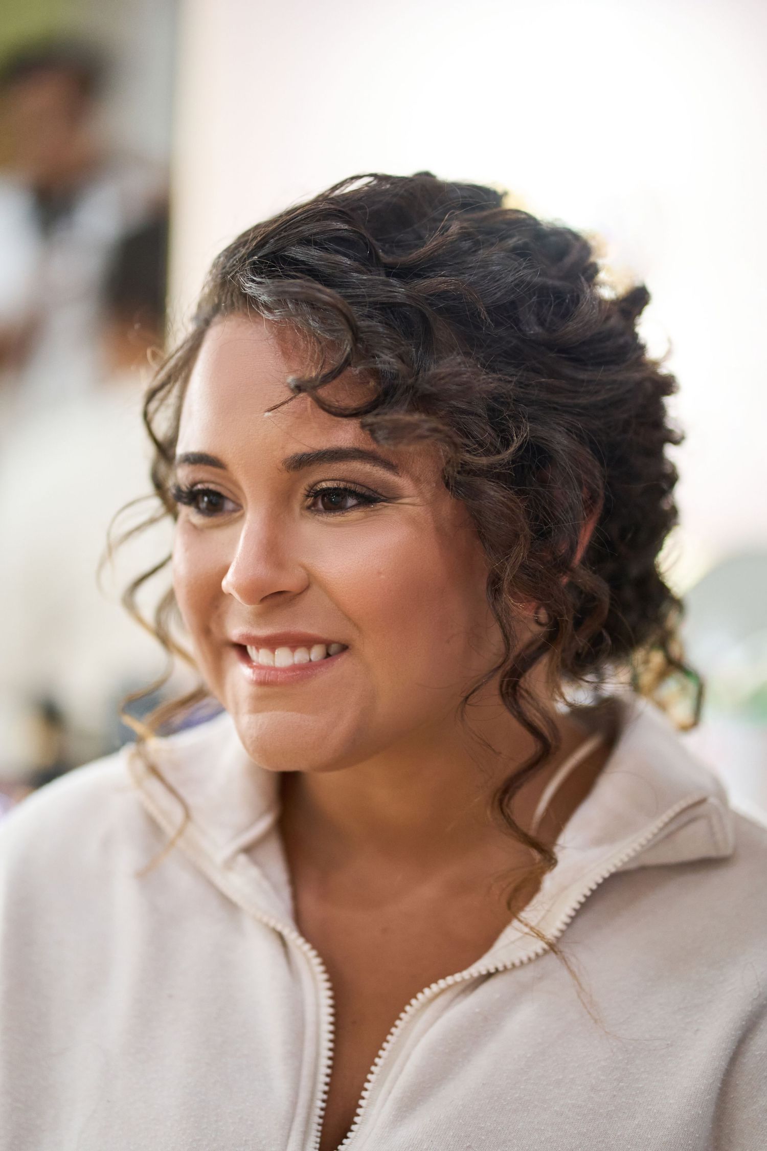 Wedding preparation candid shots showing joyful expressions and natural curly hair styling.