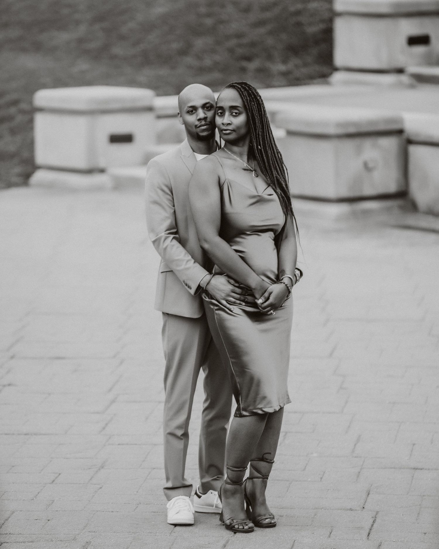 A romantic black and white portrait of a couple embracing on stone steps.