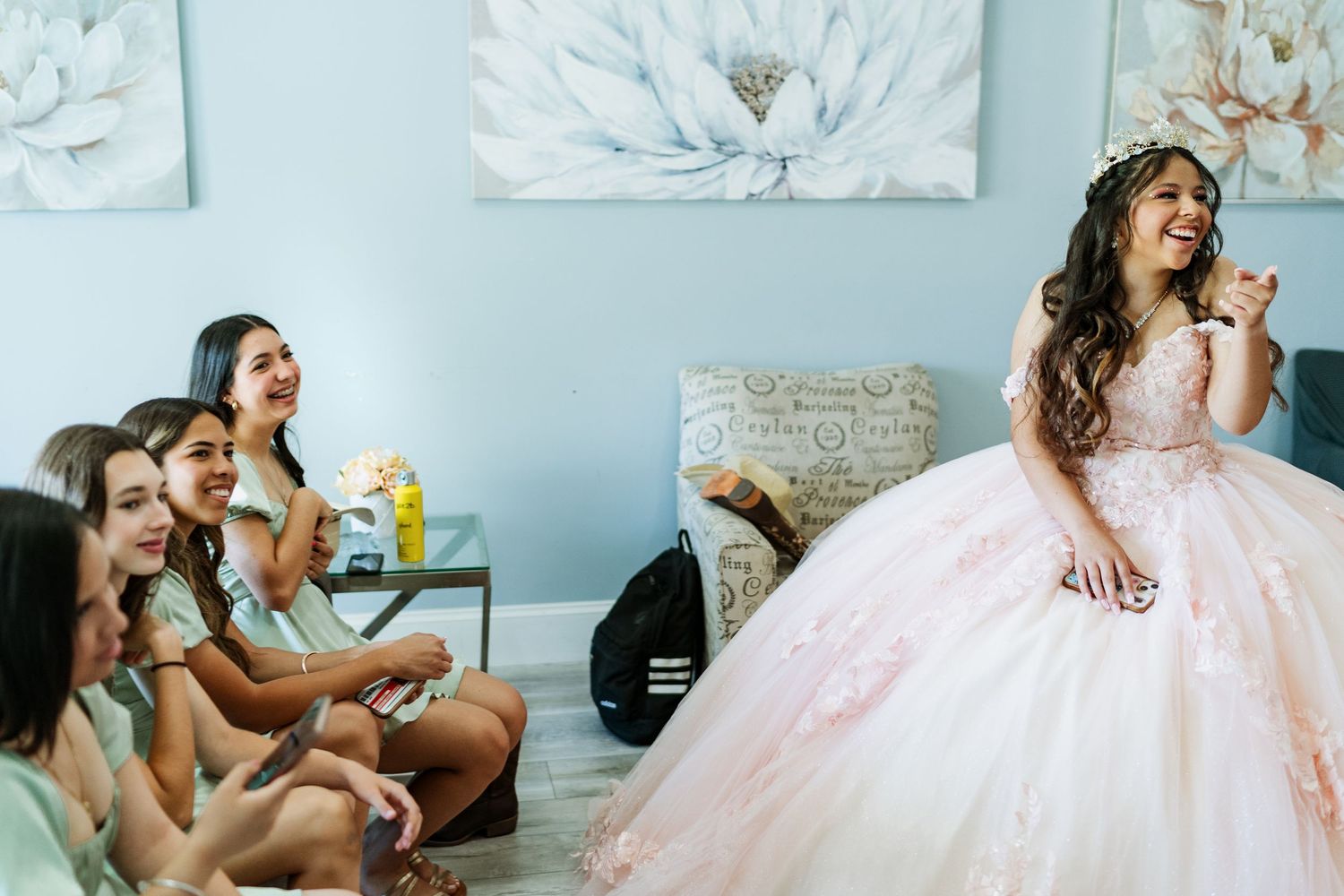 A quinceañera in a blush pink ball gown relaxing with her friends. | Quinceanera Getting Ready Photo | Munster, IN