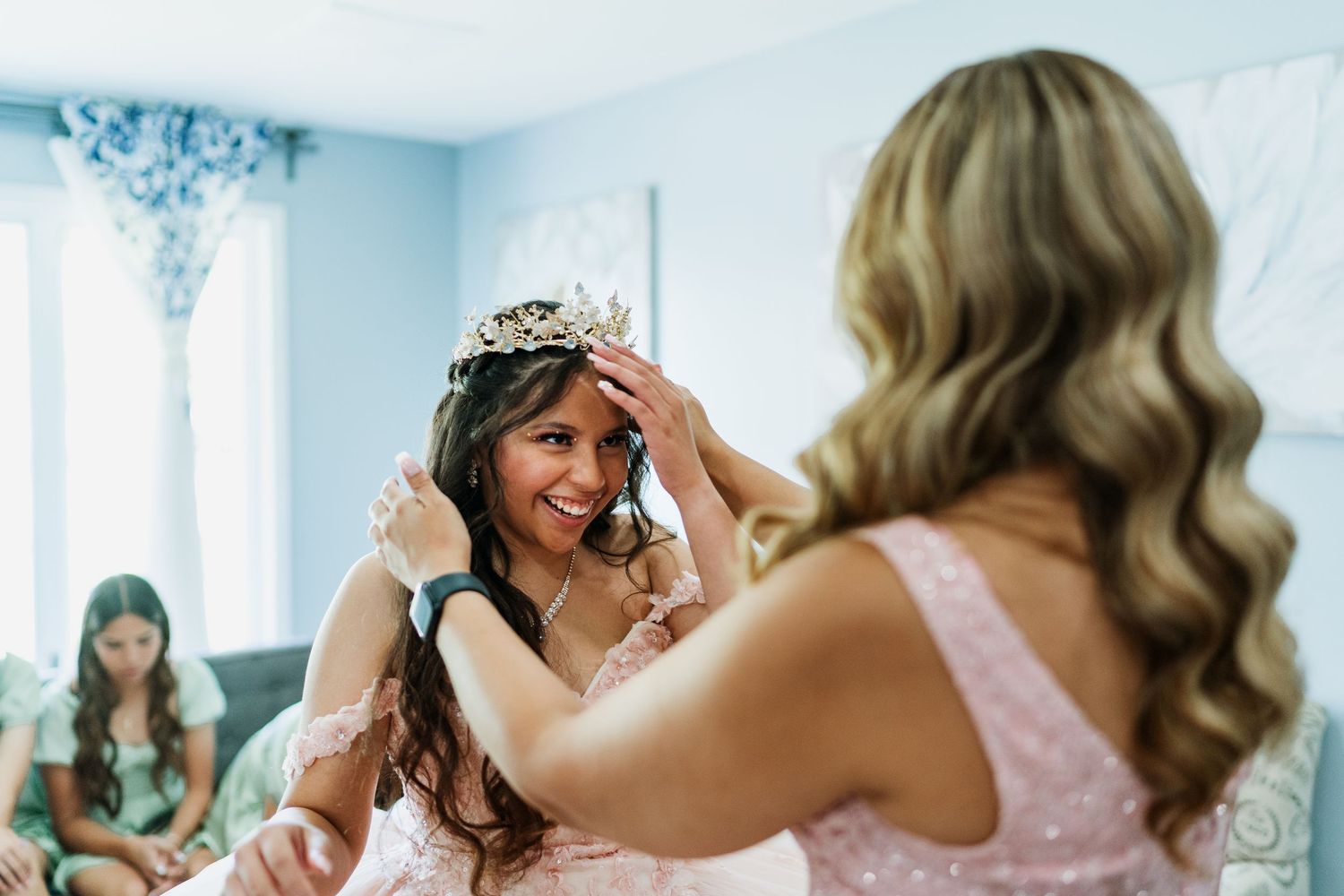 A quinceañera celebration shows a glittering tiara being placed during the traditional crowning ceremony.