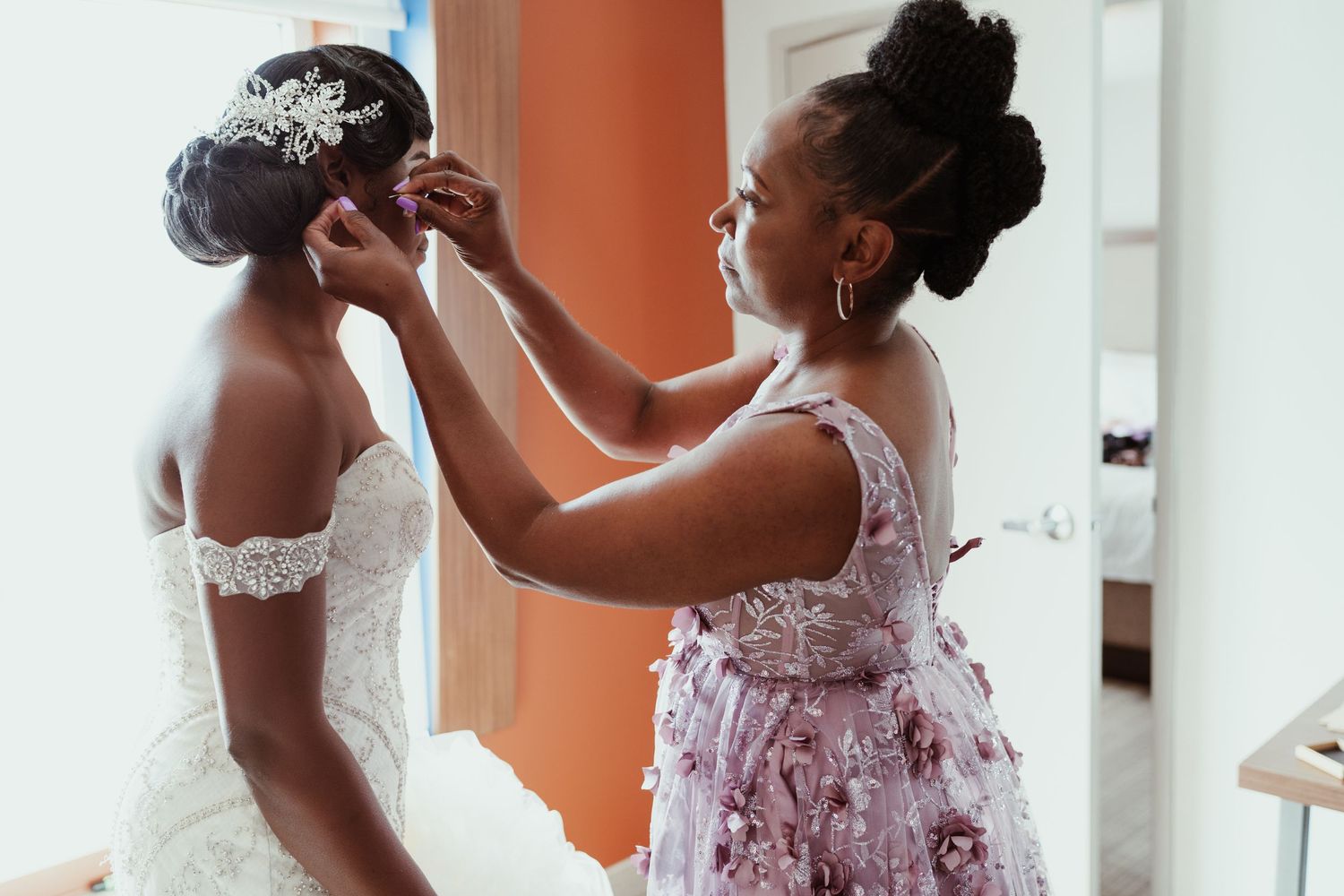 A tender moment during wedding preparations as final adjustments are made.