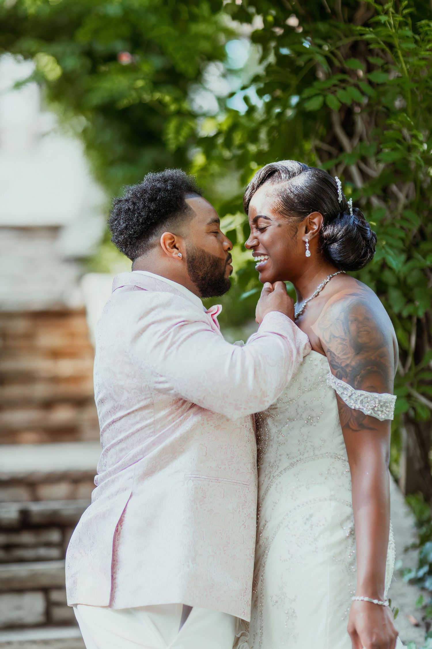 An intimate wedding moment captured as a couple shares a tender embrace outdoors.