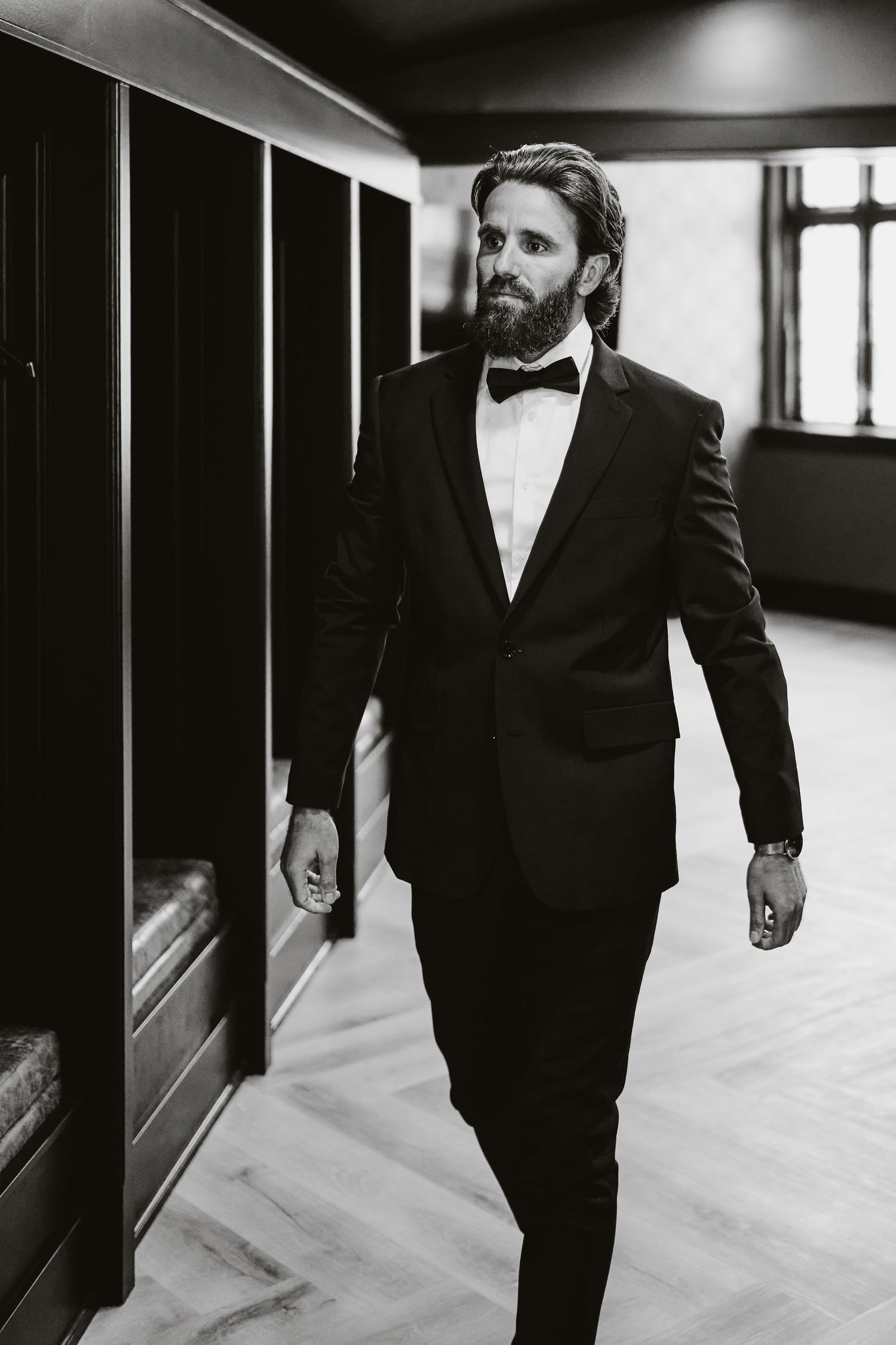 Artistic black and white portraits in a modern hallway with dramatic lighting and clean lines.