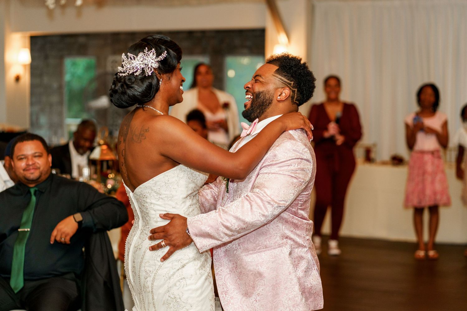 Wedding couple sharing an intimate dance moment while guests watch at their reception.