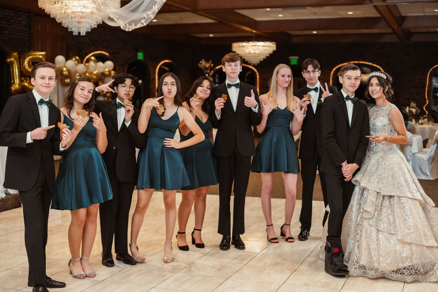 Wedding party in formal attire posing together at reception venue.