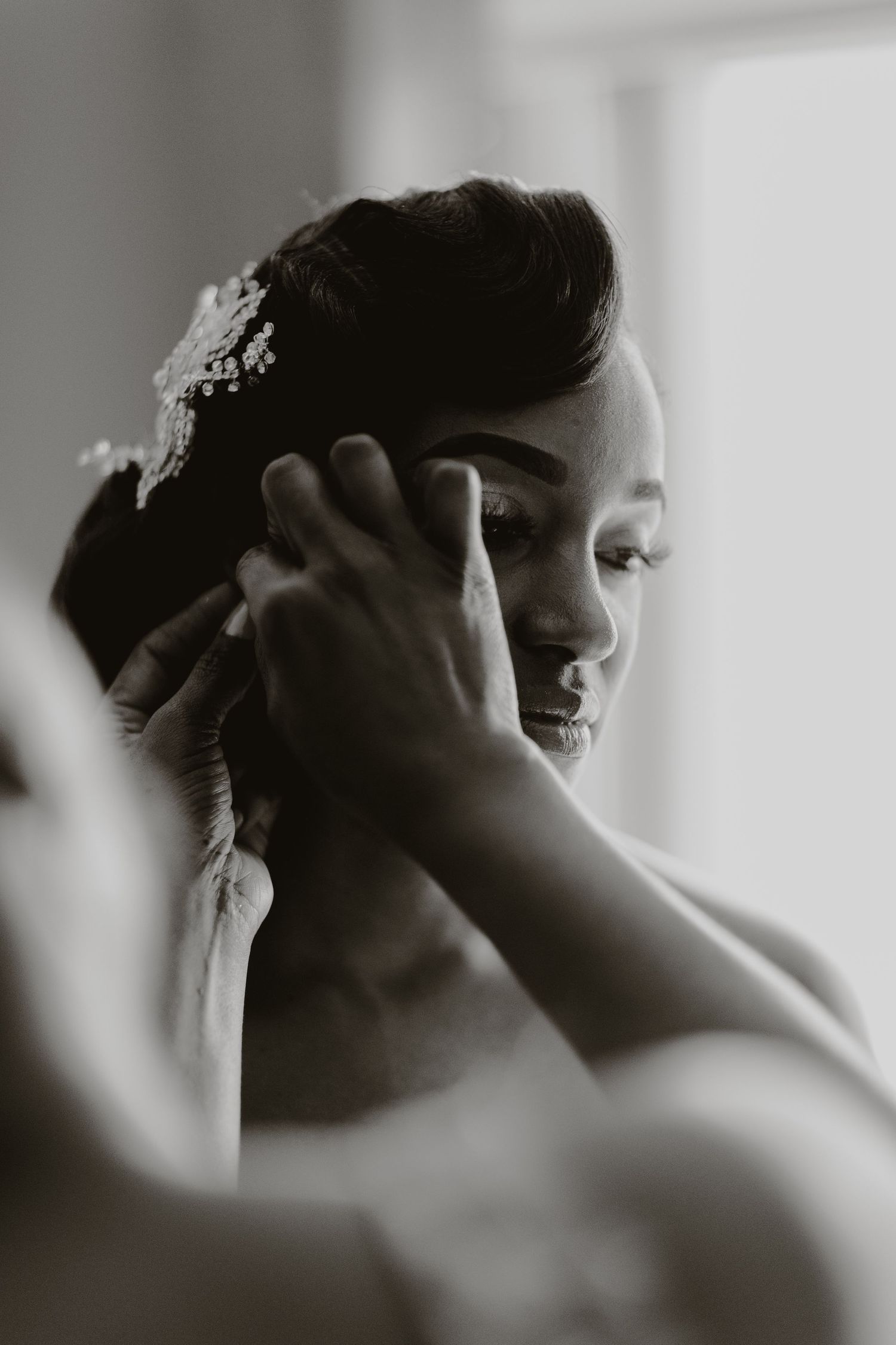 Artistic black and white portrait showing delicate bridal hair accessories and makeup.