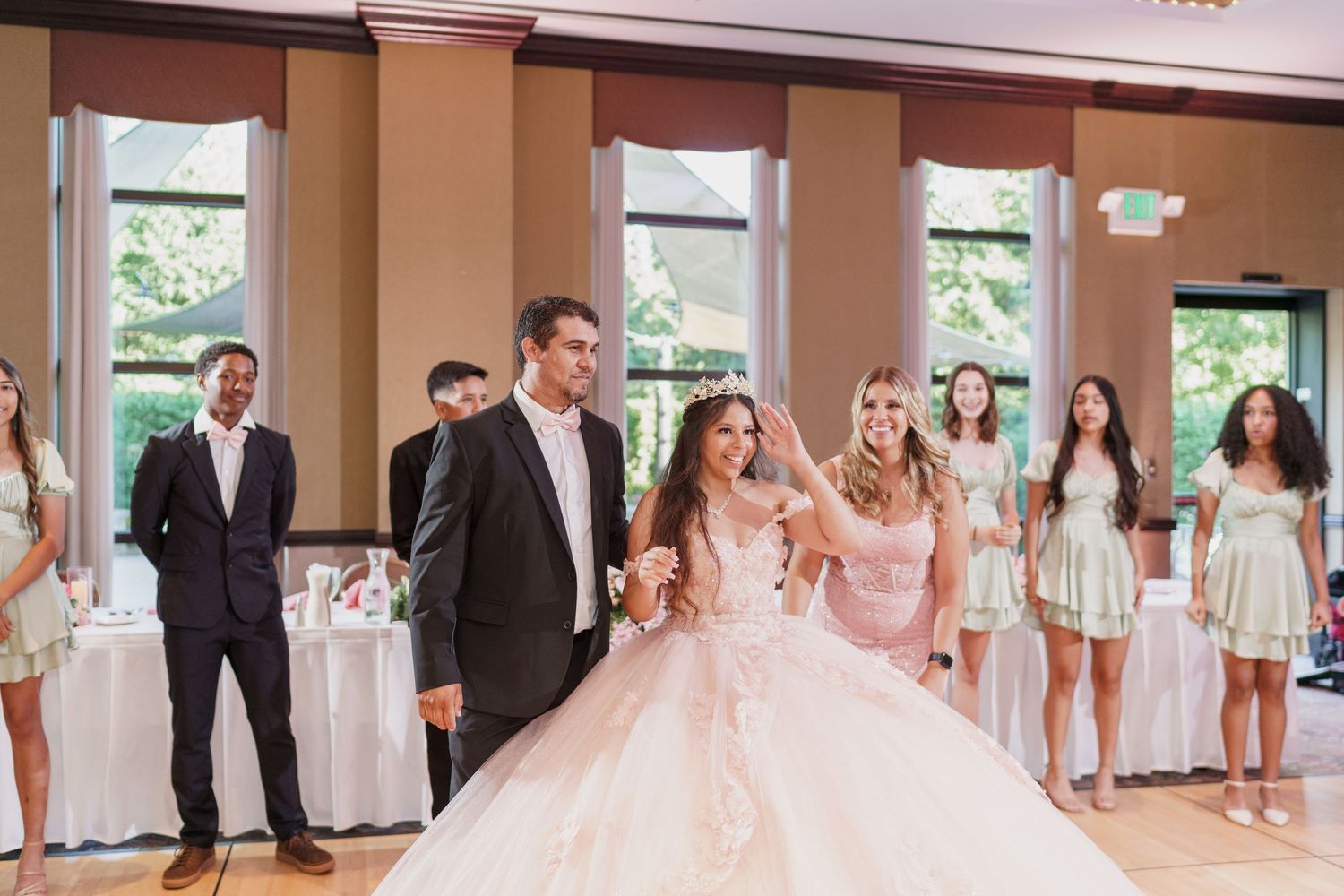 Large reception hall decorated with white linens and elegant table settings for a wedding celebration.