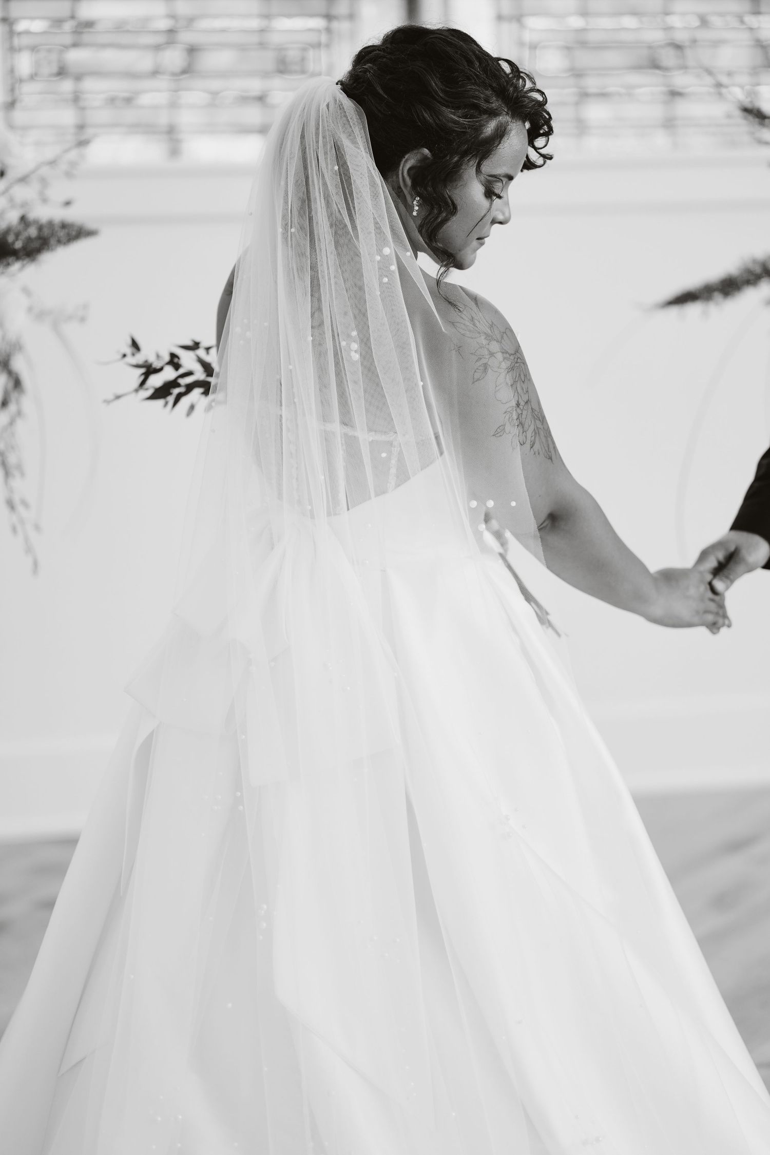 A series of black and white photos showing a bride in a flowing white wedding gown and veil from different angles.