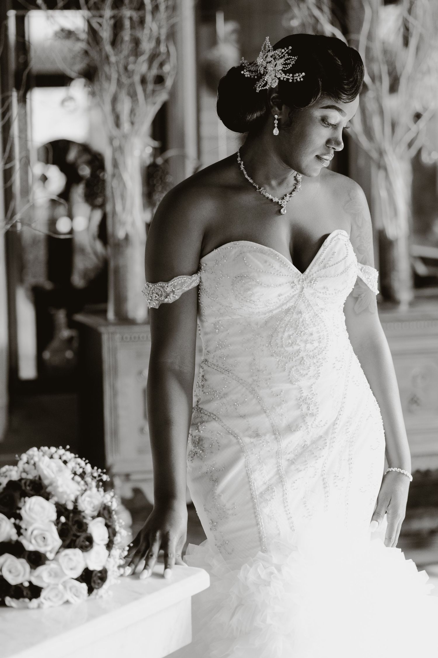 Black and white bridal portrait showcasing detailed lace gown and elegant jewelry.