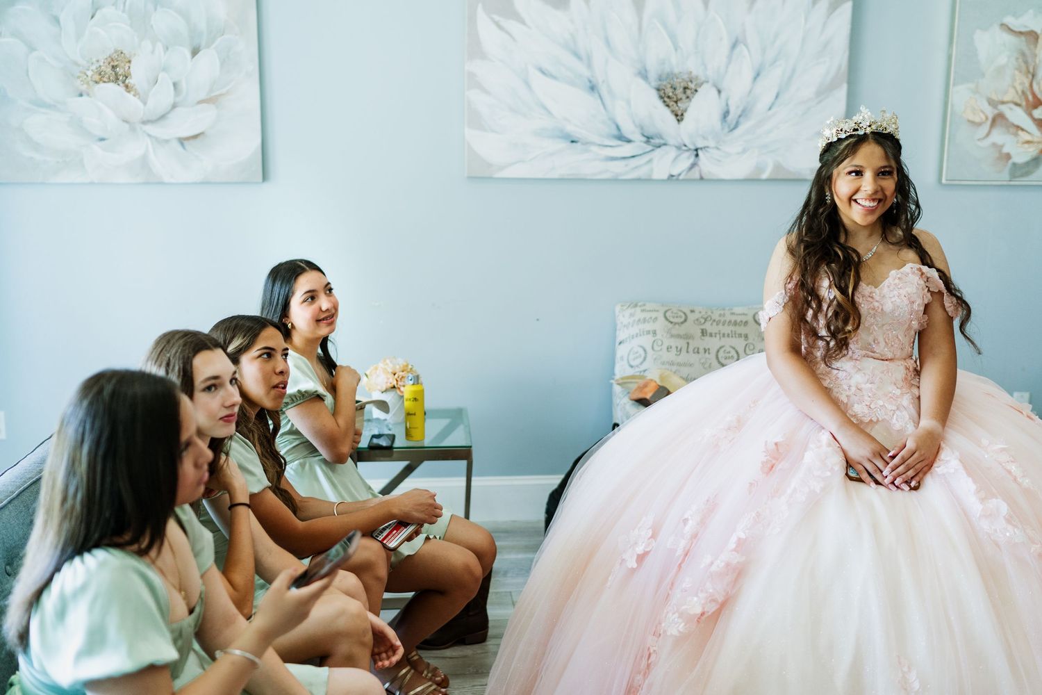 A room decorated with white floral artwork featuring a pink formal gown.
