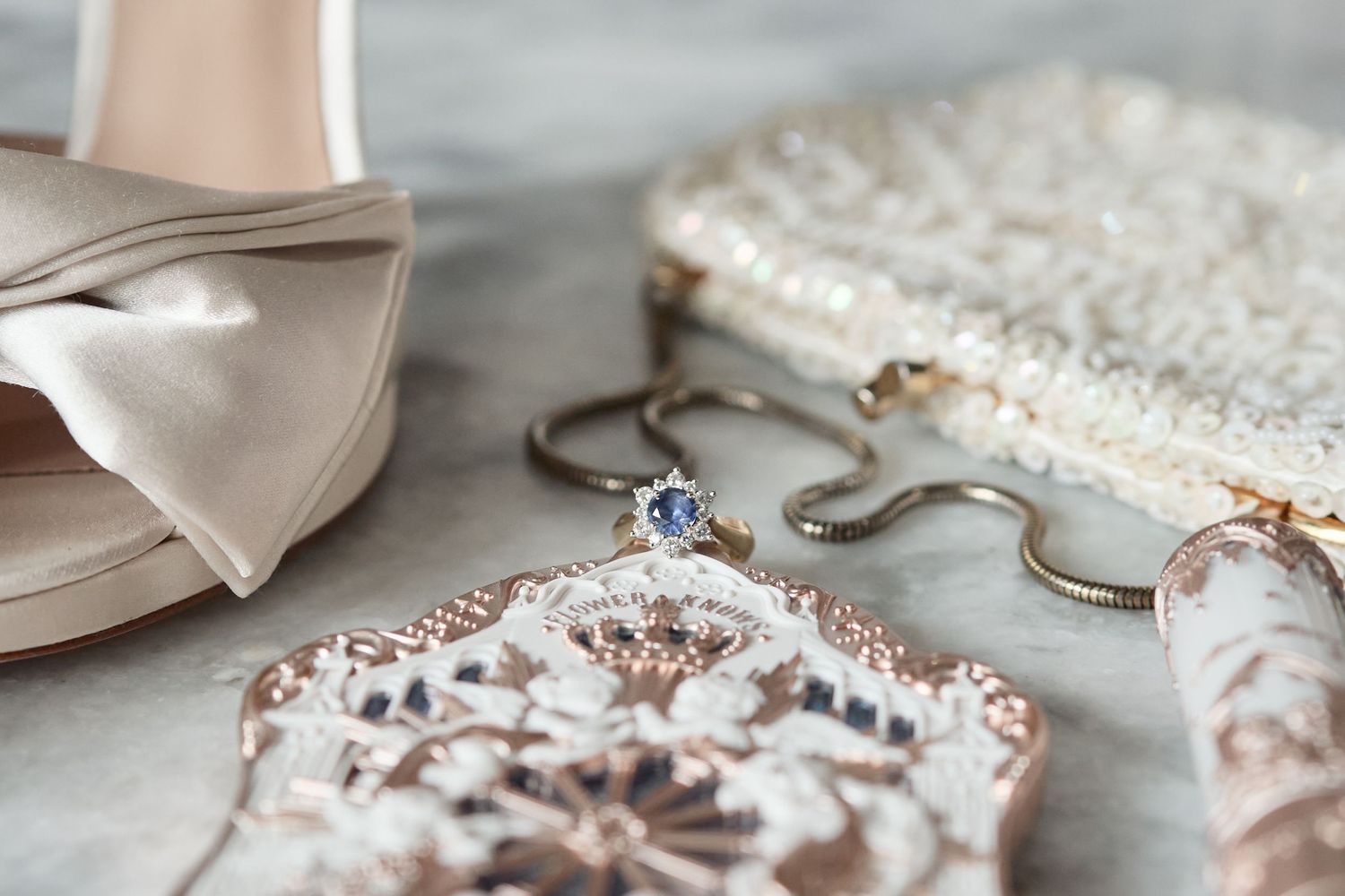 Delicate lace and pearl wedding accessories including jewelry and hair pieces arranged on light fabric.