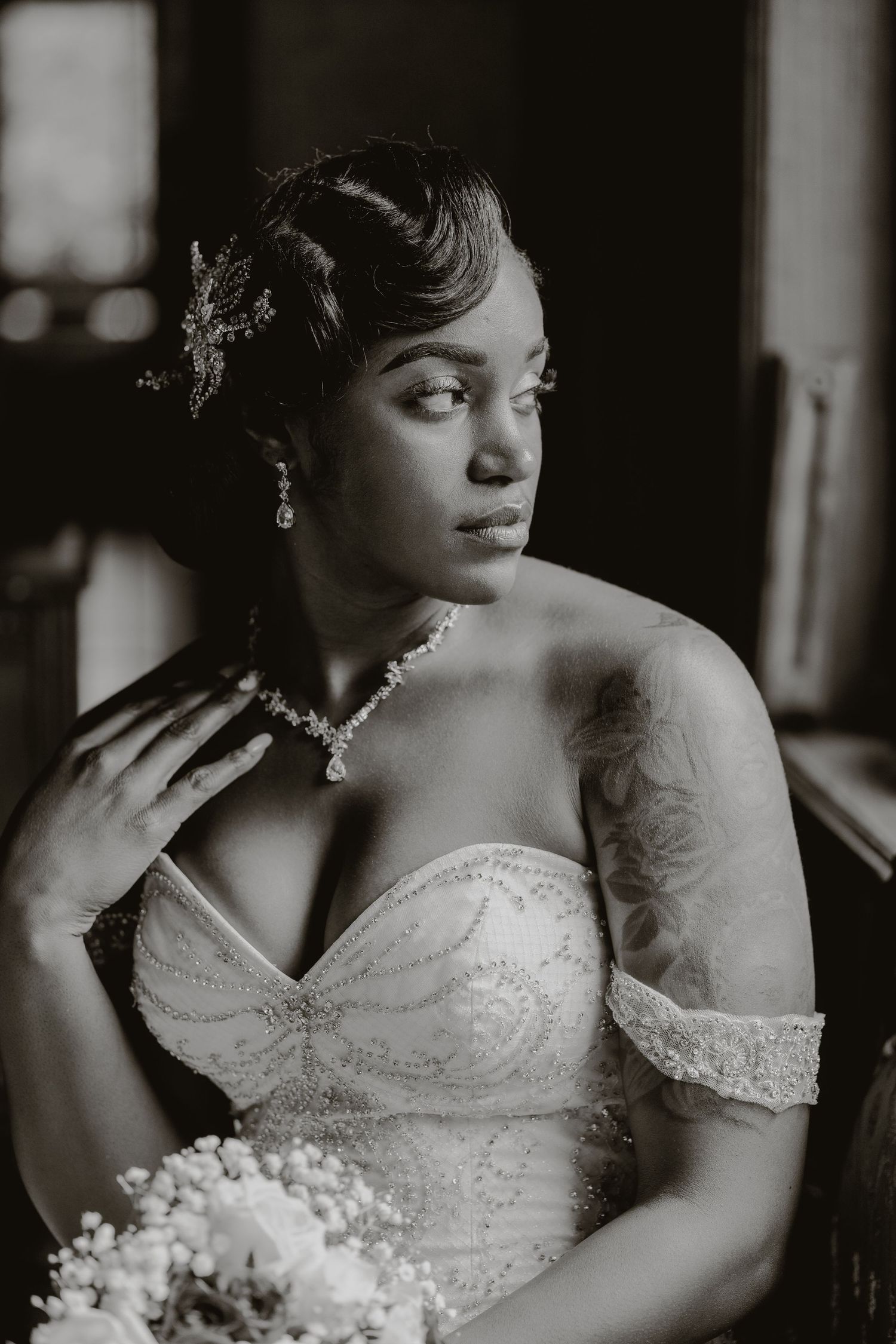 Dramatic black and white bridal portrait showcasing crystal jewelry and classic wedding gown.