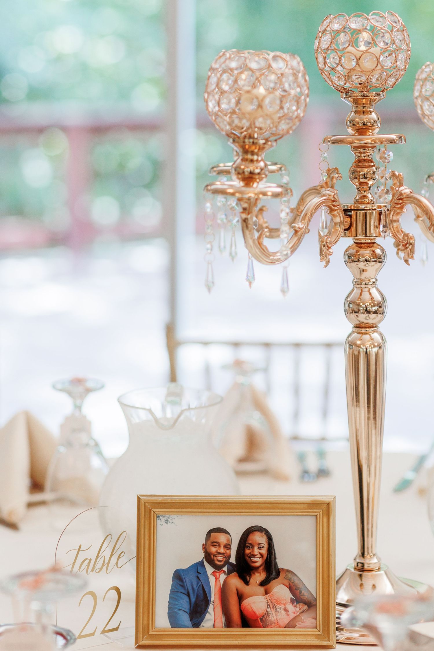Gold crystal candelabra centerpiece with framed photo on elegant table setting.