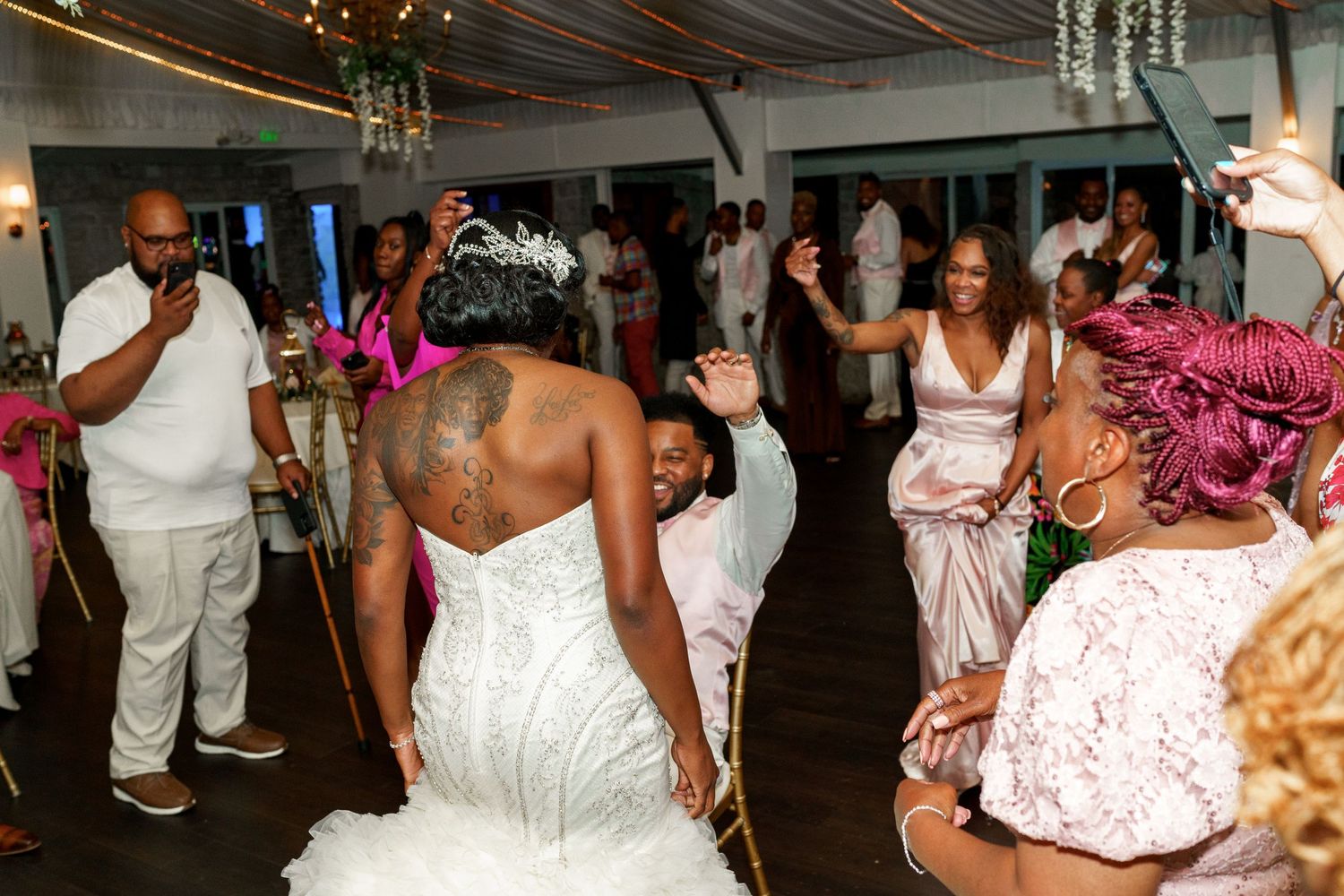 Wedding reception dance floor filled with celebratory guests in formal attire.