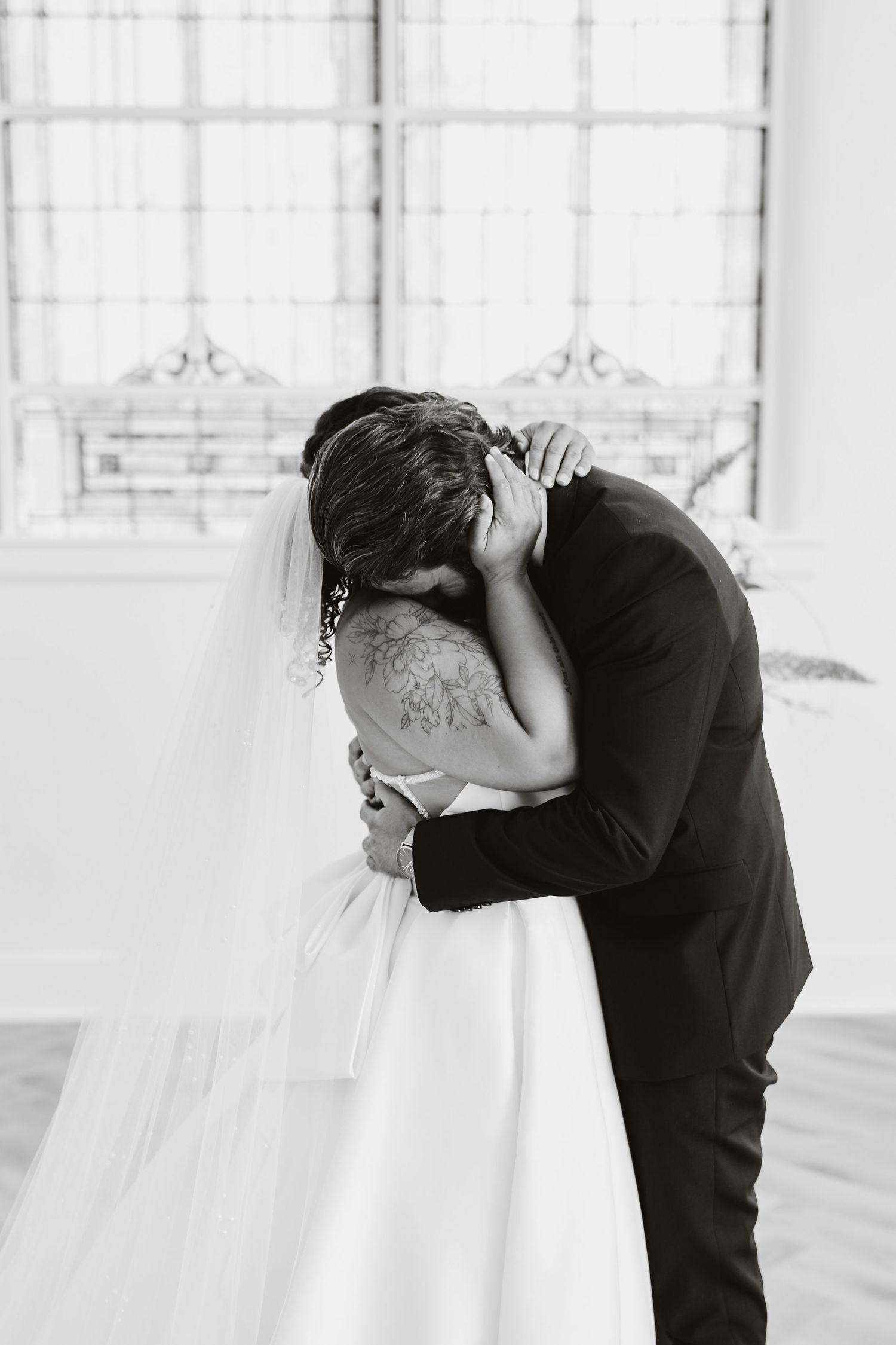Intimate black and white portrait of a wedding couple embracing.