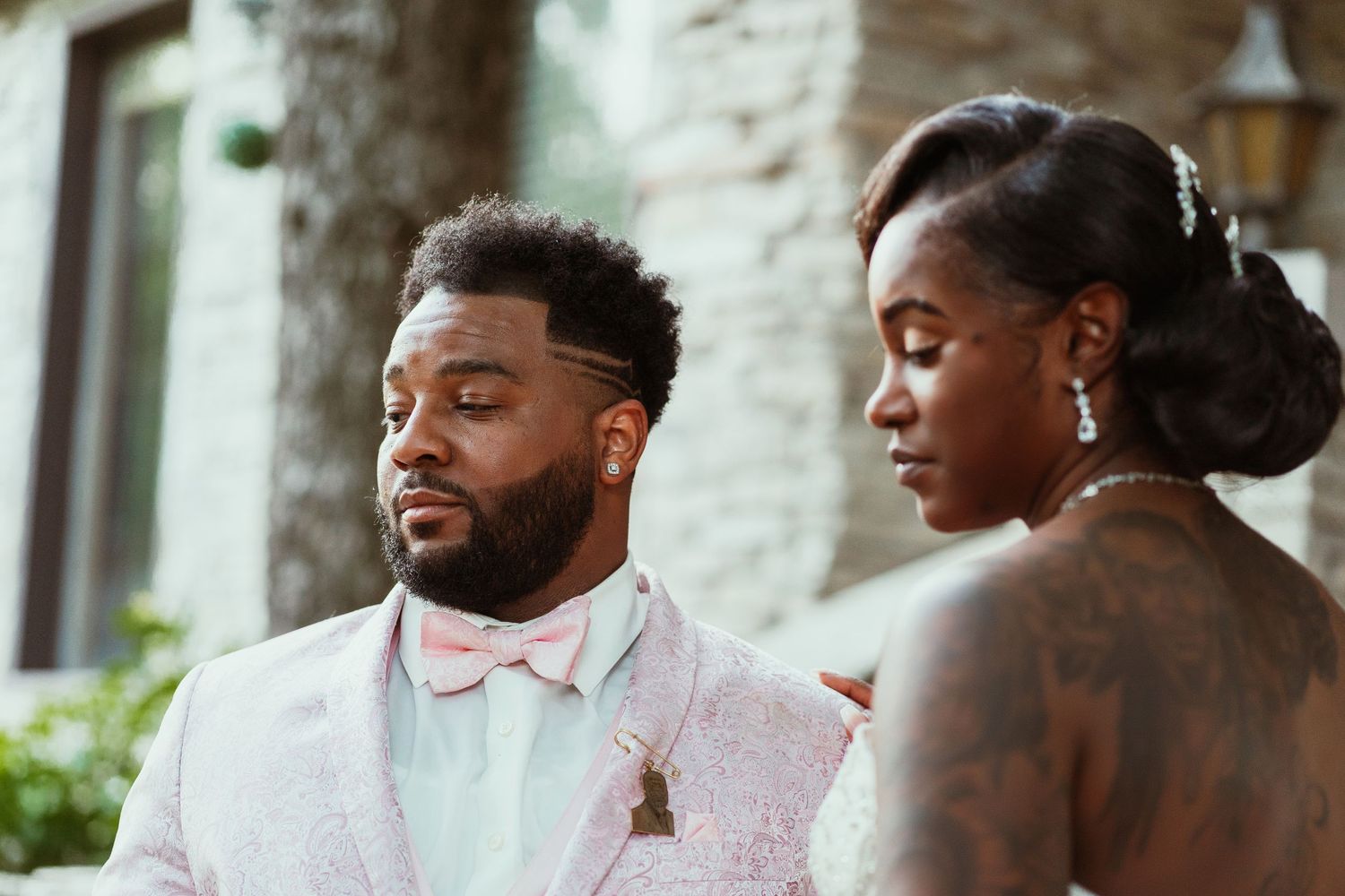 Elegantly dressed couple sharing an intimate moment during their outdoor wedding photoshoot.