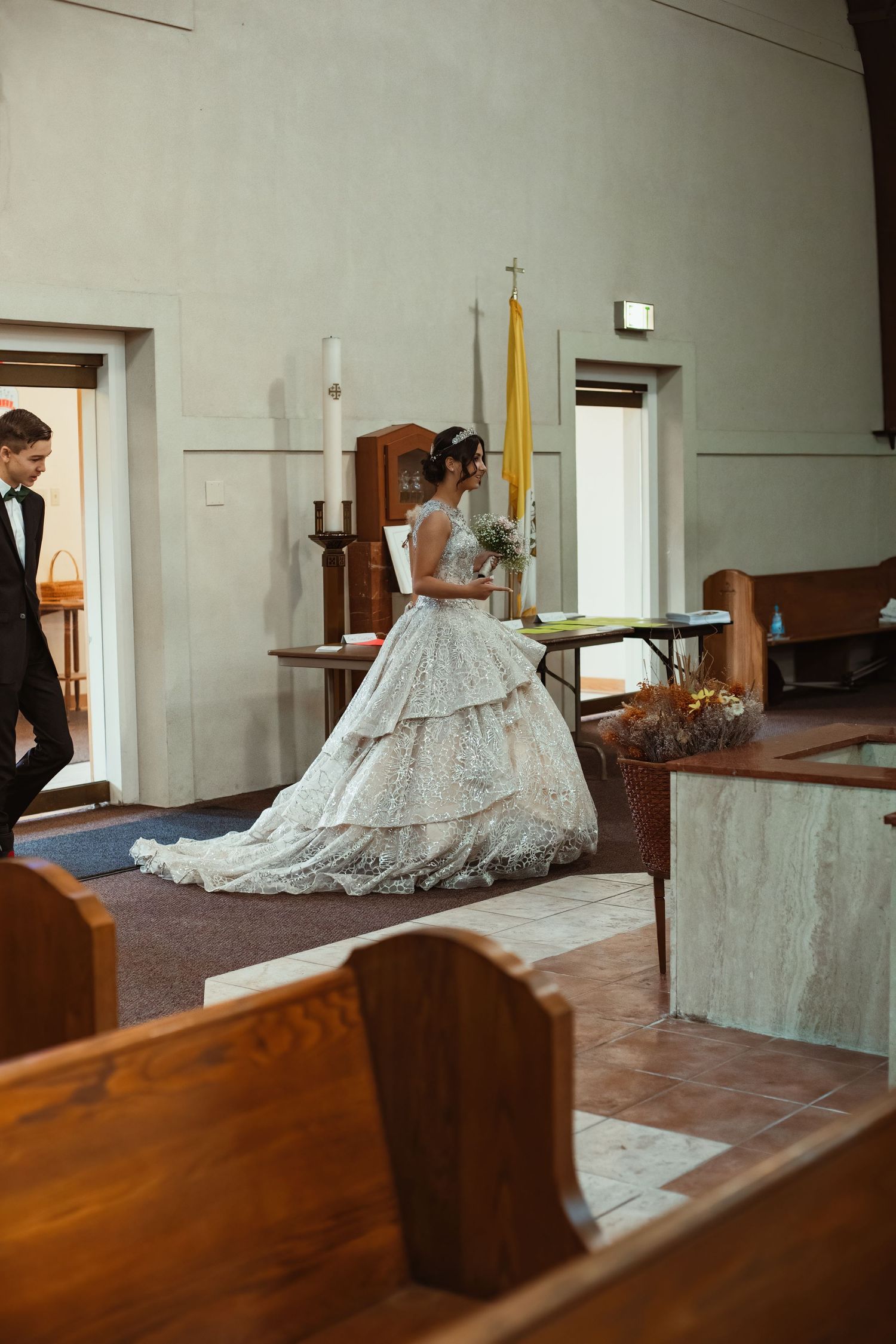 A wedding scene in a church interior with wooden pews and traditional architecture.