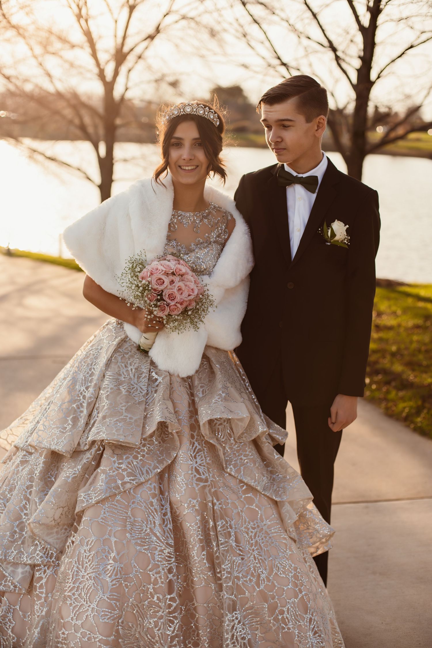 Sunset wedding portrait of couple in formal attire near waterfront.