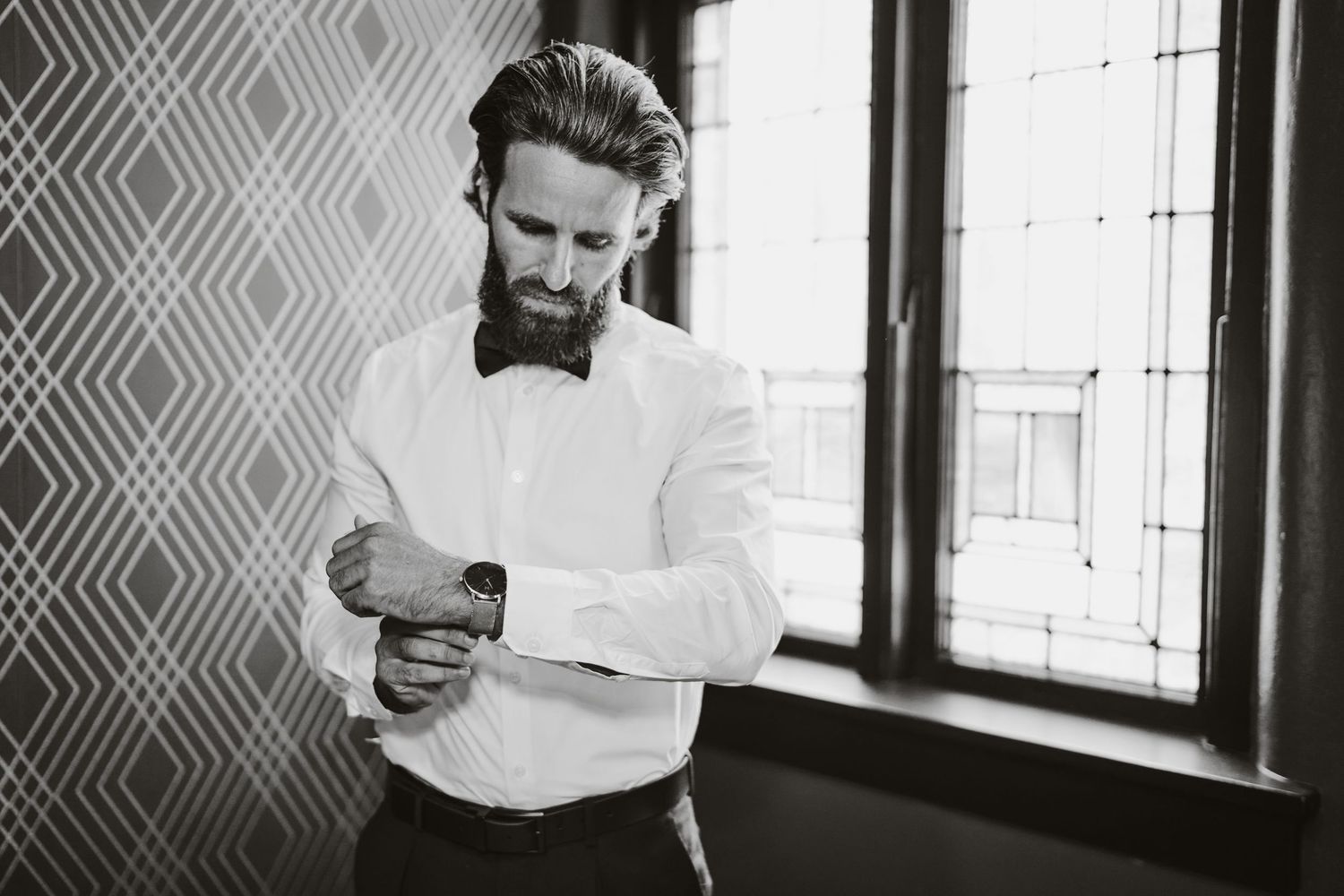 Series of black and white photos capturing intimate wedding moments in front of a window.