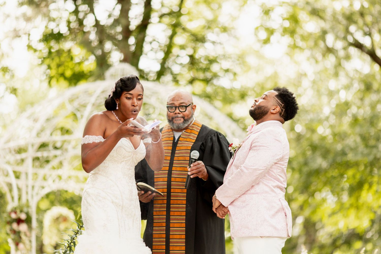 Wedding ceremony participants share a lighthearted moment during the outdoor service.