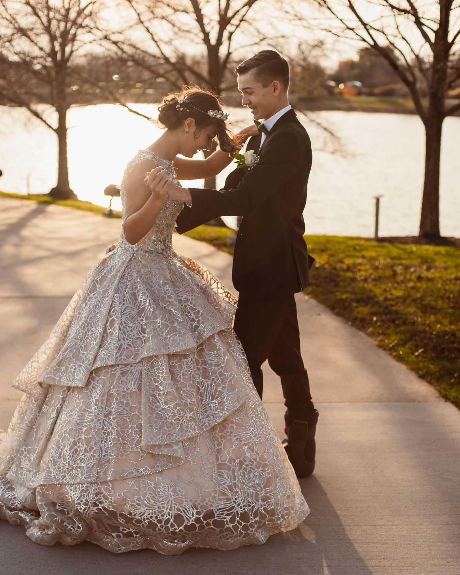 Intimate moment between couple in formal wear during sunset photo session.