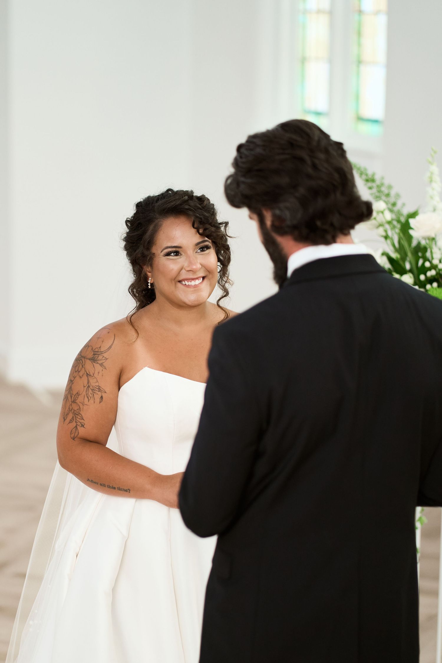 Joyful reactions during wedding first look between bride in strapless gown and groom.
