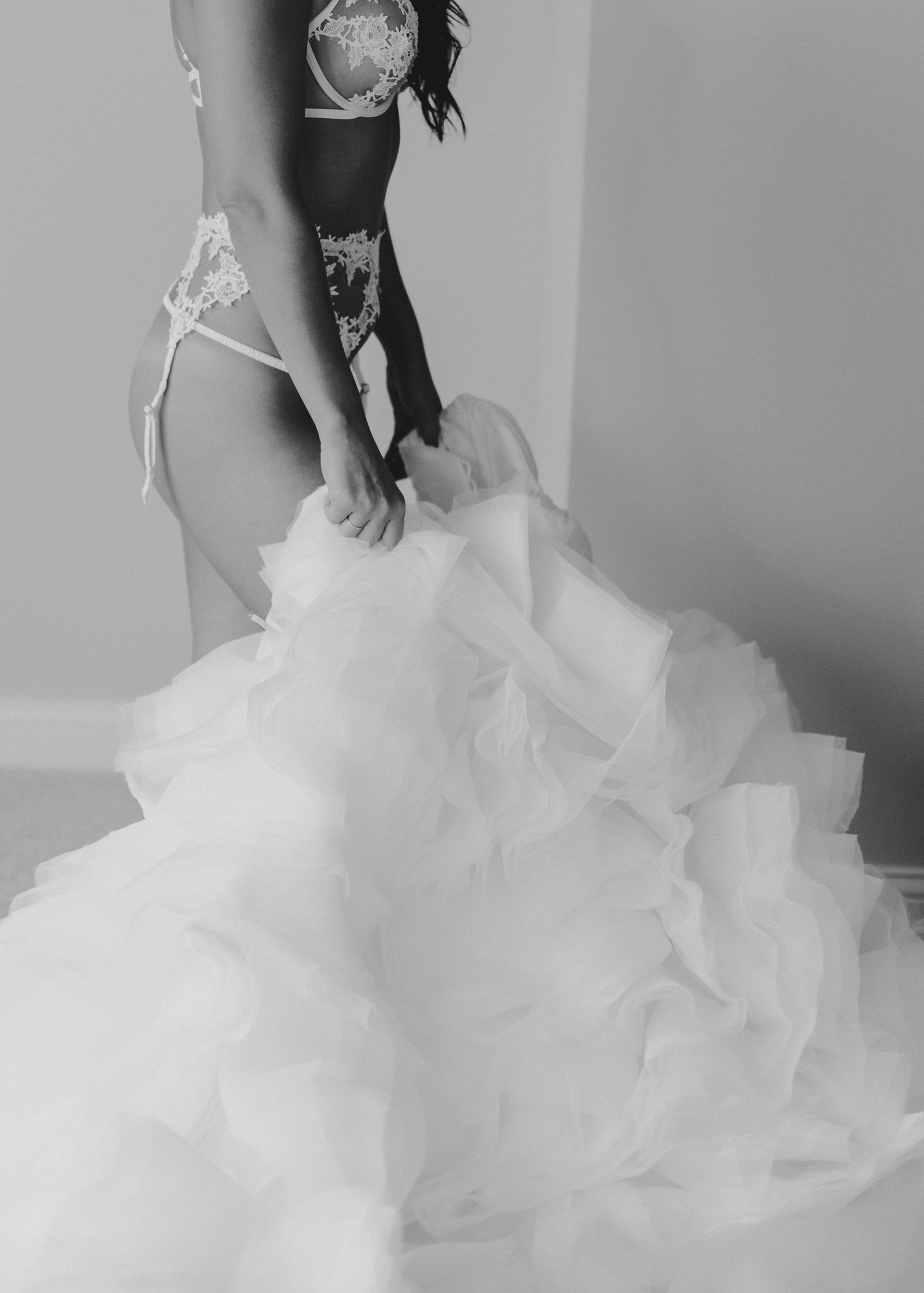 Black and white photo of voluminous ruffled wedding dress skirt.