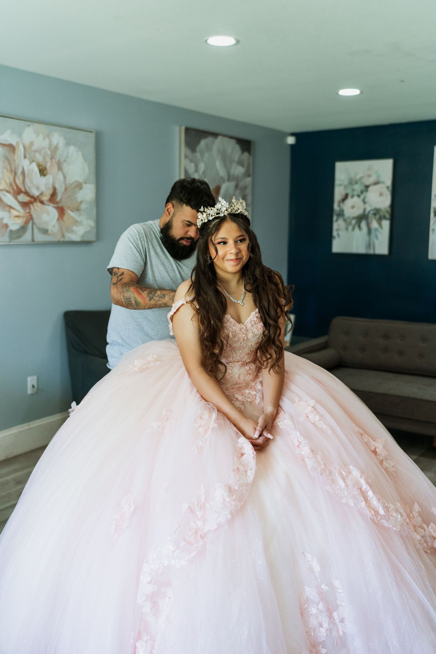 A stunning pink and white princess ball gown in a modern living room setting. | Quinceanera Getting Ready Photo | Munster, IN