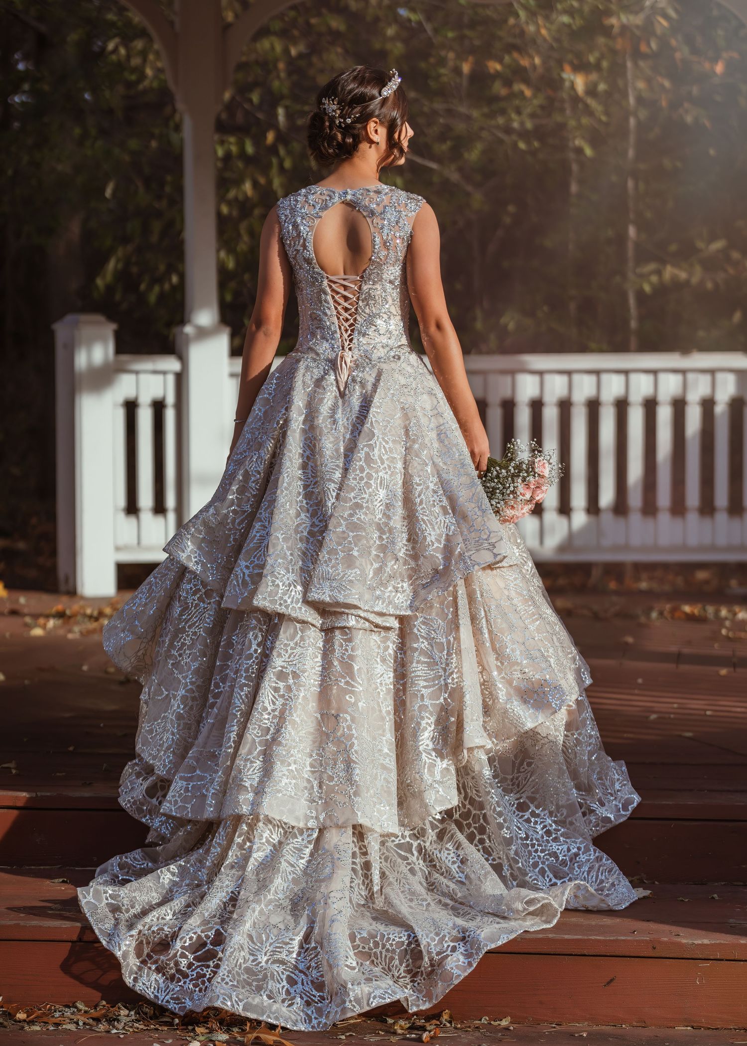 Back view of a layered wedding dress with sheer lace details and keyhole back design.