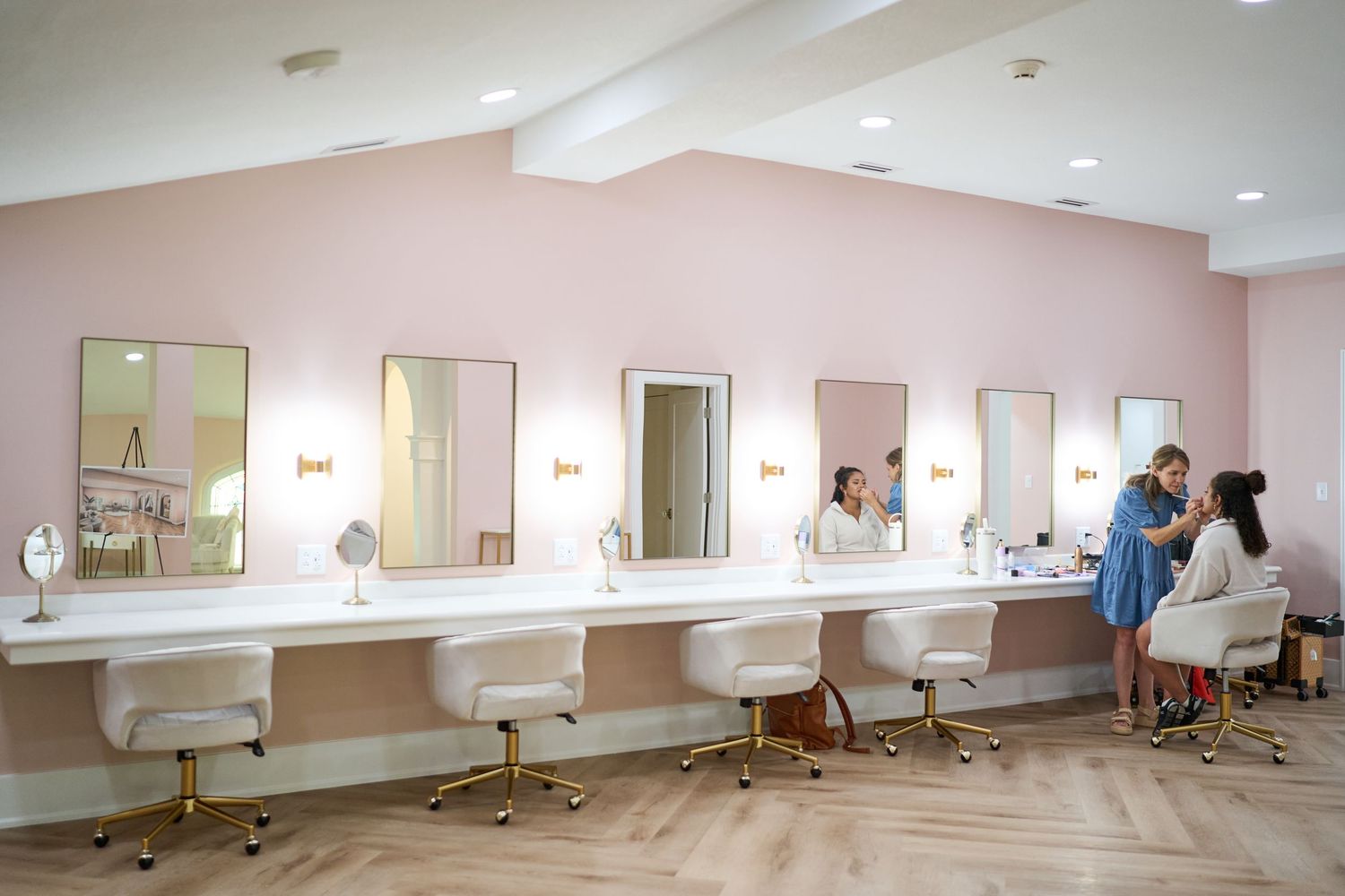 Interior photos of an empty salon space showing styling stations with mirrors and chairs arranged along cream-colored walls.