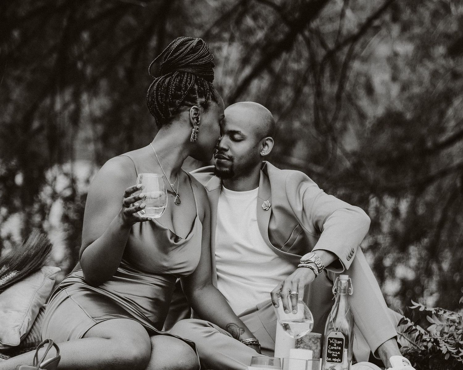 Artistic black and white portrait of couple sharing intimate moment during picnic.